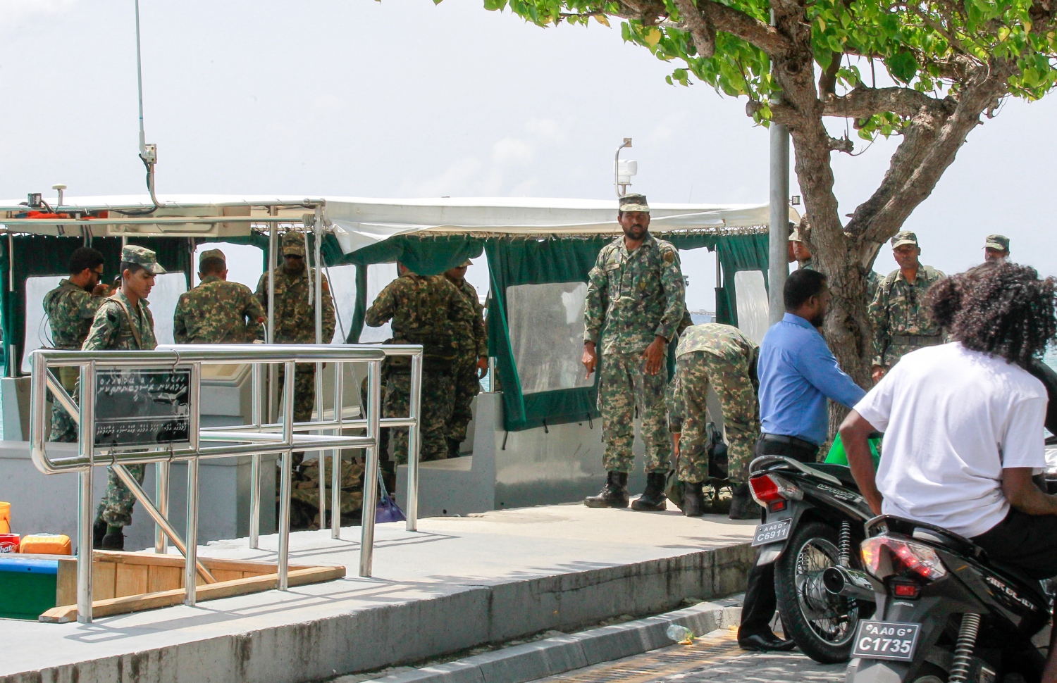 ސިފައިންތަކެއް ބަނދަރުގައި އޮތް ދޯންޏެއް ކައިރީގައި.