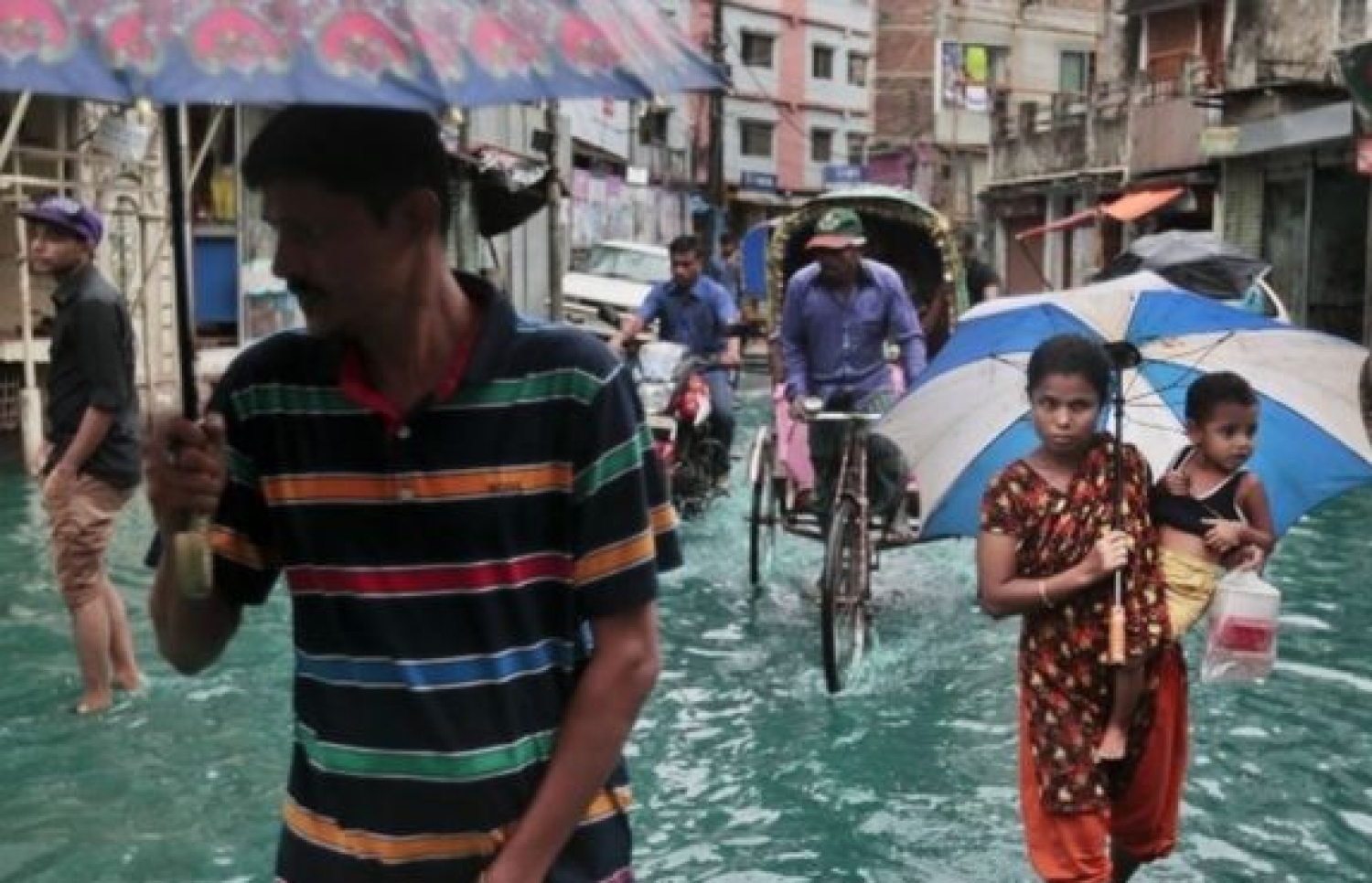 ބަނގްލަދޭޝް އަށް އެރި ތޫފާނުގައި ފެންބޮޑުވެފައިވާ މަގެއްގައި ބައެއް މީހުން ދަނީ. --ފޮޓޯ:ބީބީސީ