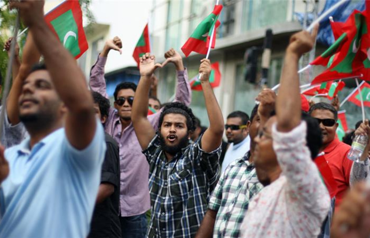 މާލޭގައި މީގެ ތިން އަހަރެއްހާ ދުވަސް ކުރިން ބޭއްވި އެއްވުމެއްގައި ބަޔަކު އަޑު އުފުލަނީ.-- ފޮޓޯ: އަލްޖަޒީރާ