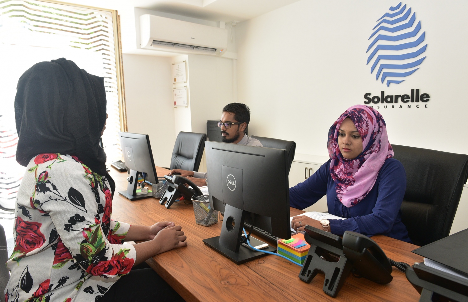 ސޮލަރެލް އިންޝުއަރެންސް އޮފީހުގައި ކަސްޓަމަރަކަށް ހިދުމަތް ދެނީ. ފޮޓޯ: މުހައްމަދު ޝަރުހާން /މިހާރު