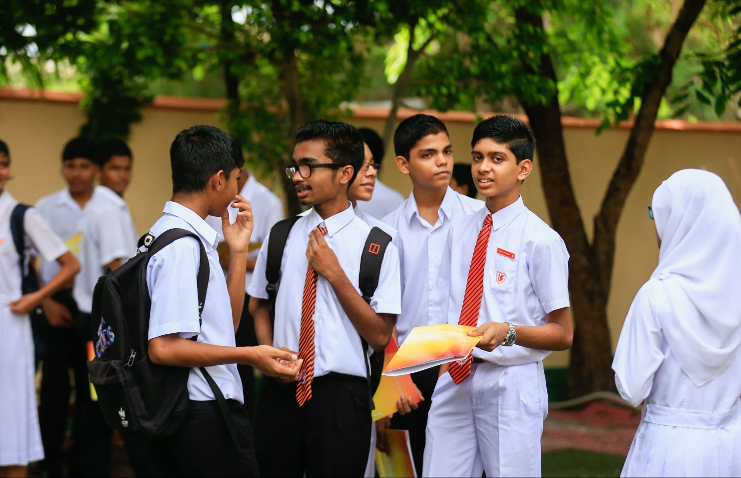 އިމާދުއްދީން ސްކޫލުގެ ދަރިވަރުންތަކެއް ރިޕޯޓު ފޮތް ހިފައިގެން ސުކޫލު ގޯތިތެރޭގައި މަޑުކޮށްލައިގެން.-- މިހާރު ފޮޓޯ:މުހައްމަދު ޝަރުހާން