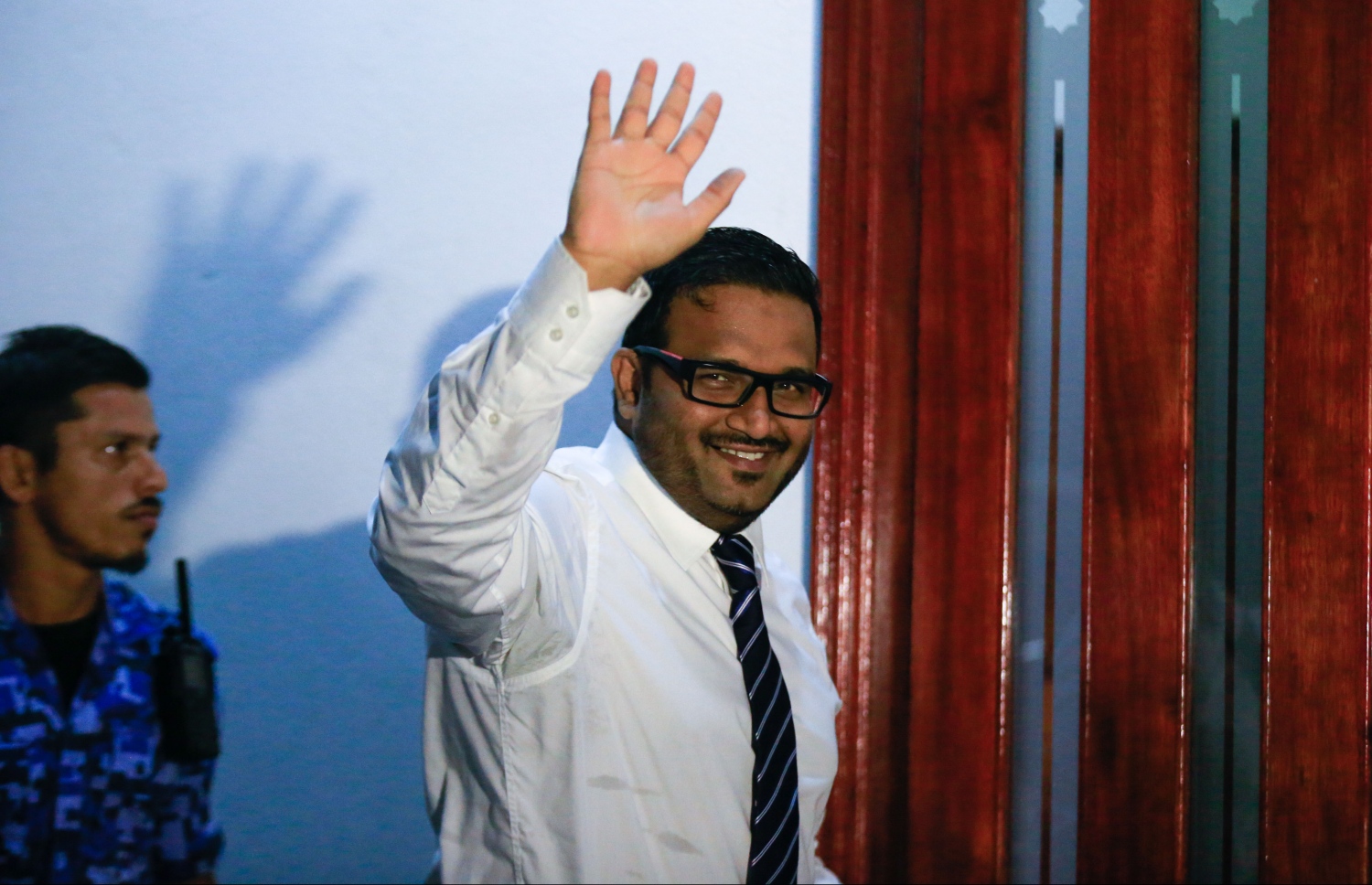 ކުރީގެ ނައިބު ރައީސް އަހްމަދު އަދީބު މިރޭ ކޯޓު ދޮރުމަތީ ހުންނަވައި، އެތަނުގައި ތިބި މީހުންނަށް އަތުން އިޝާރާތްކޮށްލައްވަނީ. -- ފޮޓޯ: މުހައްމަދު ޝަރުހާން/މިހާރު