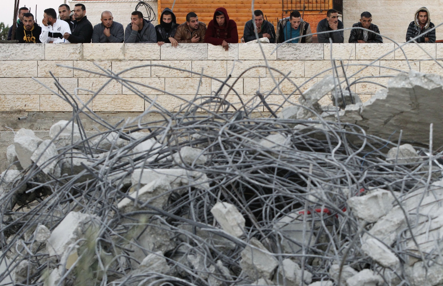 ފަލަސްތީނުގެ ކުޑަ ކުއްޖާގެ ގެ އިޒްރޭލުން ހަލާކު ކުރަމުންދާ އިރު ފަލަސްތީނުގެ ކުޑަ ކުއްޖާގެ އާއިލާގެ މީހުން ބަލަނީ. --ފޮޓޯ:އޭއެފްޕީ