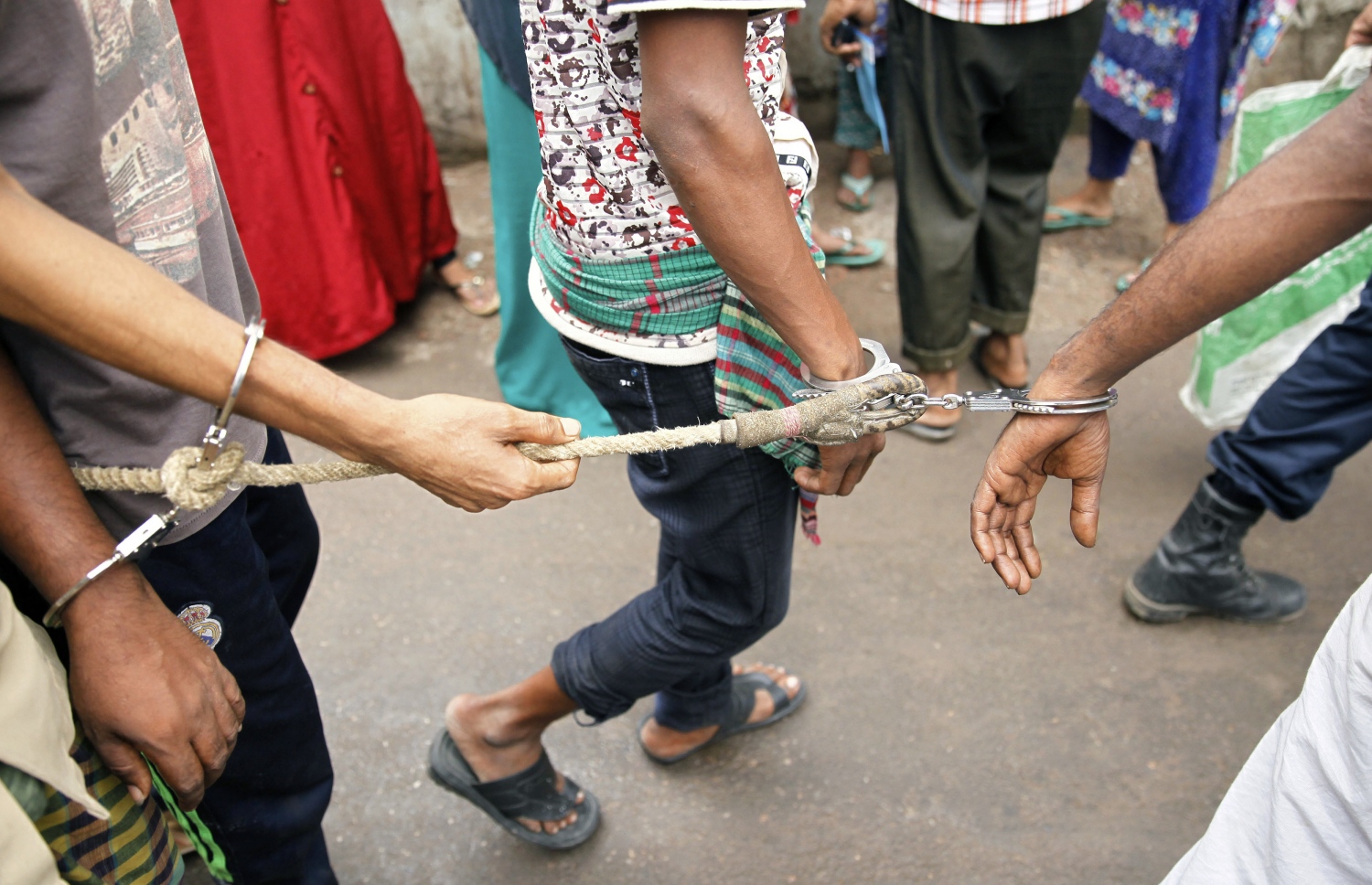 ބަންގްލަދޭޝް އިން ހައްޔަރު ކުރި މީހުން ބިޑި އަޅުވައިގެން ފުލުހުންގެ ބެލުމުގެ ދަށުން ގެންދަނީ. --ފޮޓޯ:އޭއެފްޕީ