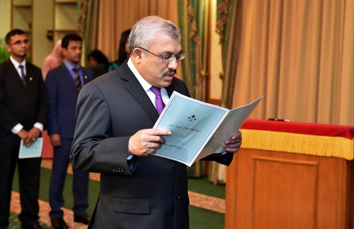 ޖޫން 22، 2016، މާލެ: ނައިބު ރައީސްގެ މަގާމު ހުސްކޮށް އޮންނަތާ ނުވަ މަސް ފަހުން، ފިނޭންސް މިނިސްޓަރުގެ މަގާމުގައި ހުންނެވި އަބްދުﷲ ޖިހާދު ނައިބު ރައީސްގެ މަގާމަށް މިއަދު އައްޔަން ކުރެއްވުމުން ރައީސް ޔާމީންގެ ކުރިފުޅުމަތީ މަގާމުގެ ހުވާ ކުރައްވަނީ. --ފޮޓޯ ރައީސް އޮފީސް