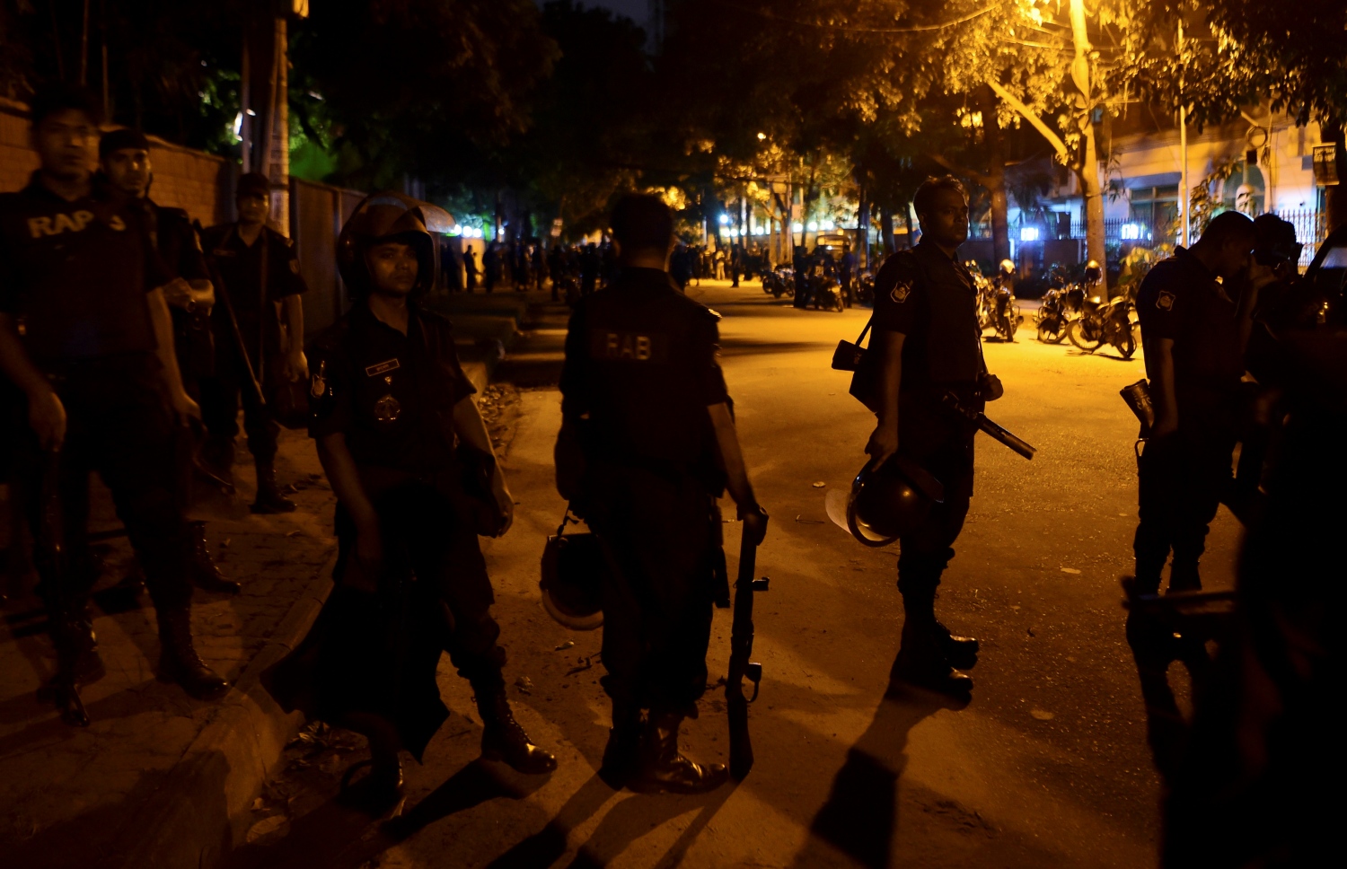 މީހުން ރަހީނުކުރި ކެފޭގެ ބޭރުގައި ބަންގްލަދޭޝްގެ ސިފައިން ހަރަކާތްތެރި ވަނީ. --ފޮޓޯ:އޭއެފްޕީ