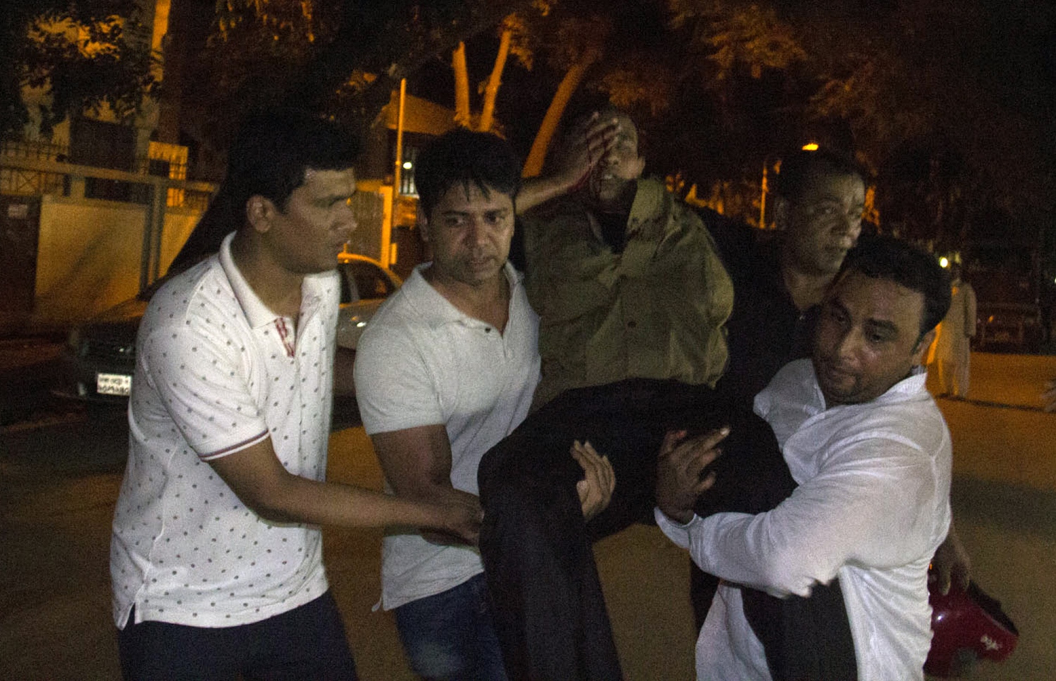 މީހުން ރަހީނު ކުރި ކެފޭ އިން ޒަޚަމްވި މީހަކު ގެންދަނީ. --ފޮޓޯ:އޭއެފްޕީ