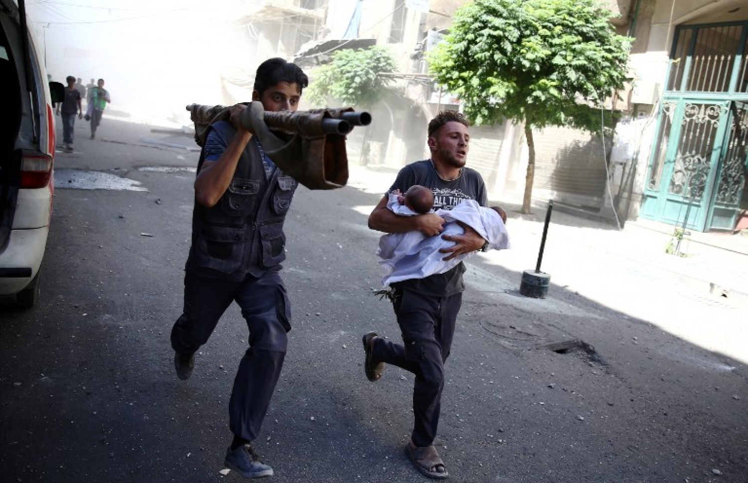 ސީރިއާގެ ވެރިރަށް ދިމިޝްގުގެ އިރުން އޮންނަ ސަރަހައްދެއްގައި ދިން ވައިގެ ހަމަލާތަކުން ސަލާމަތް ވުމަށް ކުޑަ ކުއްޖަކު ގޮވައިގެން ދަނީ. --ފޮޓޯ:އޭއެފްޕީ