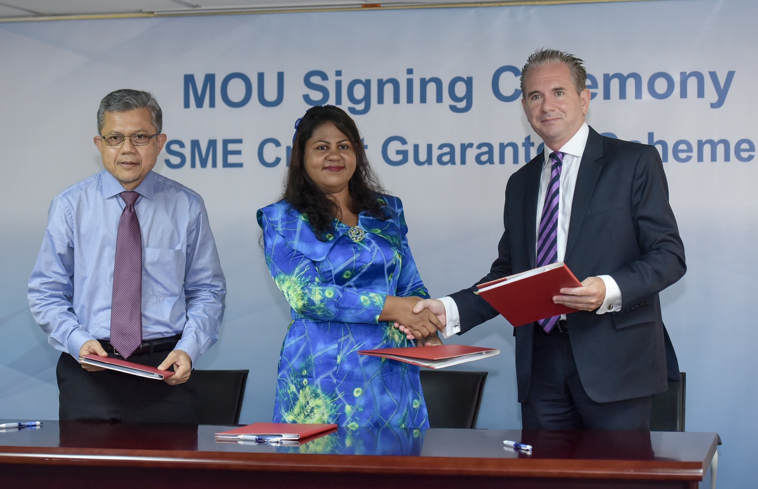 ކްރެޑިޓް ގެރެންޓީ ސްކީމްގެ އެއްބަސްވުމުގައި ސޮއިކުރުމަށް ފަހު ގަވަރުނަރު އަޒީމާ އާއި ބީއެމްއެލް ސީއީއޯ އެންޑްރޫ ހީލީ ސަލާމް ކުރައްވަނީ. ފޮޓޯ: ނިޝާން އަލީ