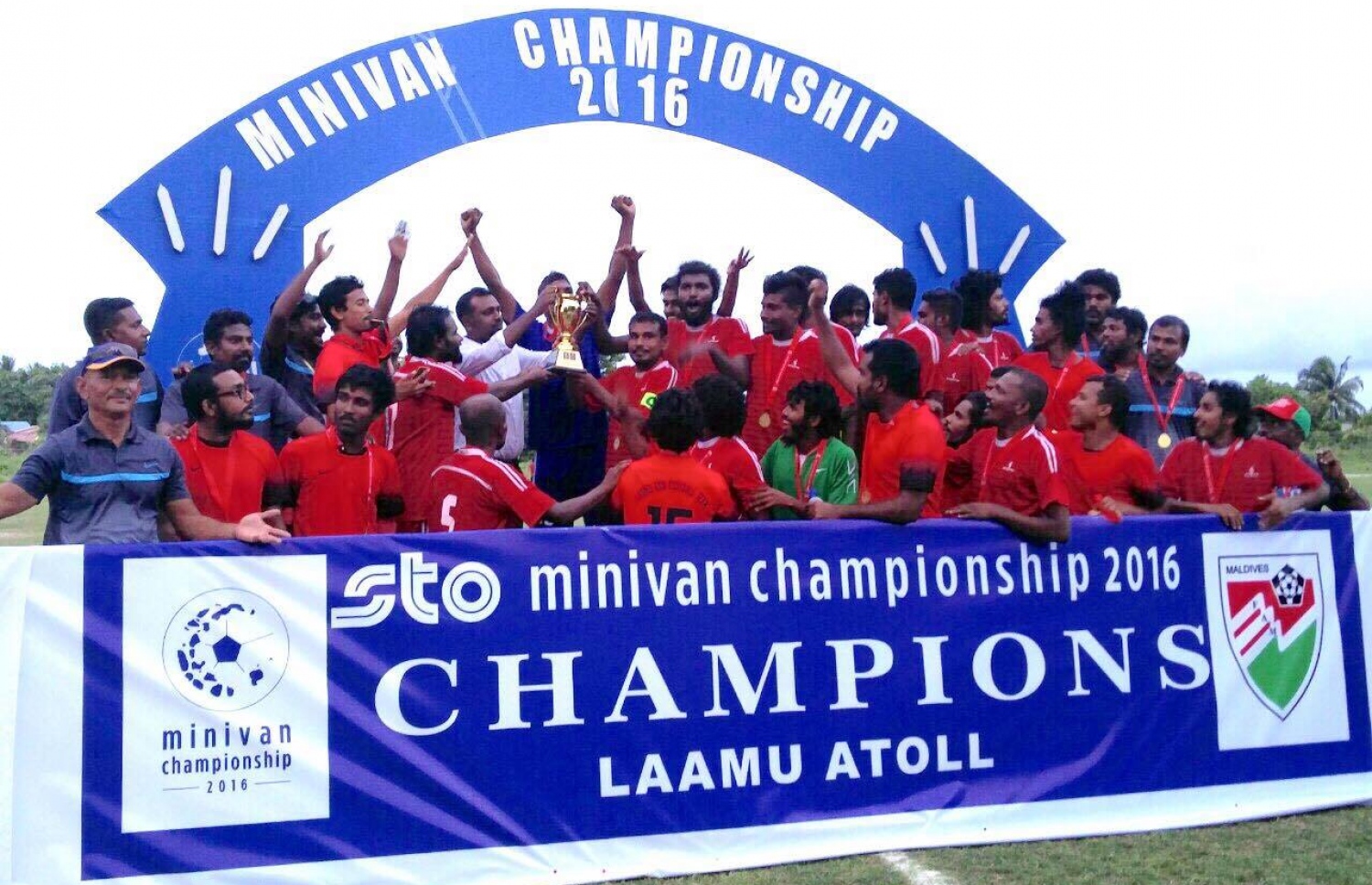 ލ. އަތޮޅު ޗެމްޕިއަން ގަން ޓީމުގެ ކެޕްޓަންއާ ތަށި ހަވާލުކުރަނީ. --ފޮޓޯ: އެފްއޭއެމް