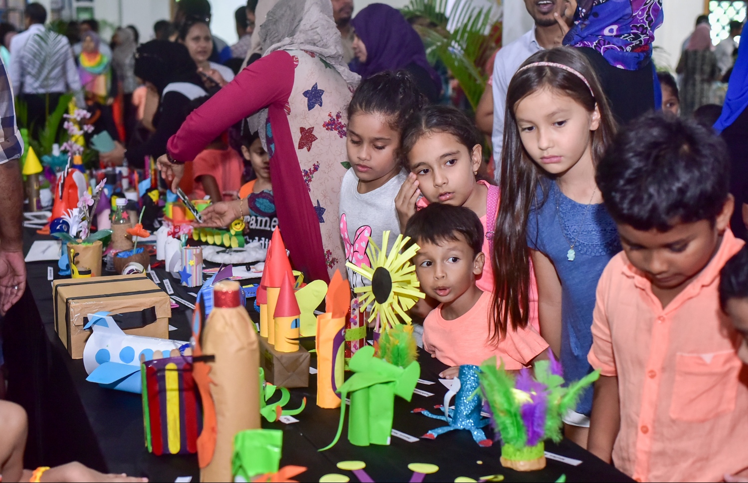 ކެންގަރޫކިޑްސް އާޓް އެގްޒިބިޝަންގެ ތެރޭގައި ބައެއް ދަރިވަރުން އައިޓަމްތައް ބަލާލަނީ: ކޮންމެ އަހަރަކު ވެސް މިފަދަ އެގްޒިބިޝަން ކުރިއަށްގެންދޭ.-- ފޮޓޯ: ނިޝާން އަލީ/ މިހާރު