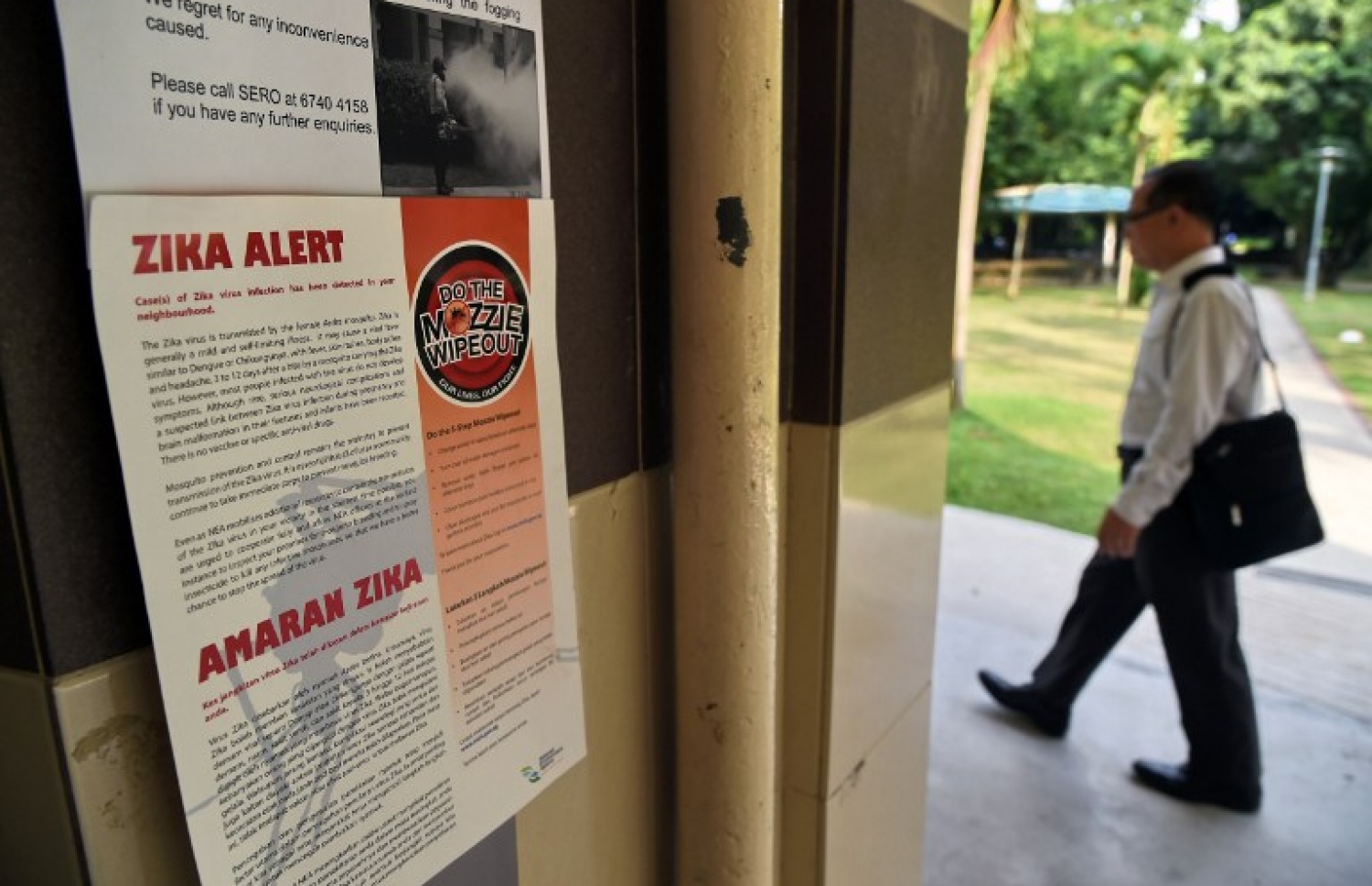 ޒިކާ ވައިރަސްއާ މެދު ހޭލުންތެރި ކުރުވަން ސިންގަޕޫރުގައި ބަހައްޓާފައިވާ ނޯޓިސްއެއްގެ ކައިރިން މީހަކު ދަނީ. --ފޮޓޯ:އޭއެފްޕީ