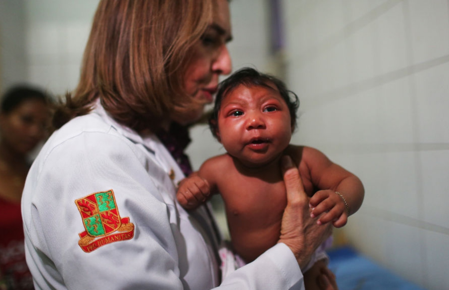 ޑޮކްޓަރަކު، ޒިކާގެ ސަބަބުން އައިބުވެފައިވާ ކުއްޖަކު އުރާލައިގެން: މަދިރީގެ ސަބަބުން ޖެހޭ މި ބަލިން، ބޮޑު އައިބު ކަމެއް އުފެދޭ -- ފޮޓޯ: ގެޓީ އިމޭޖަސް