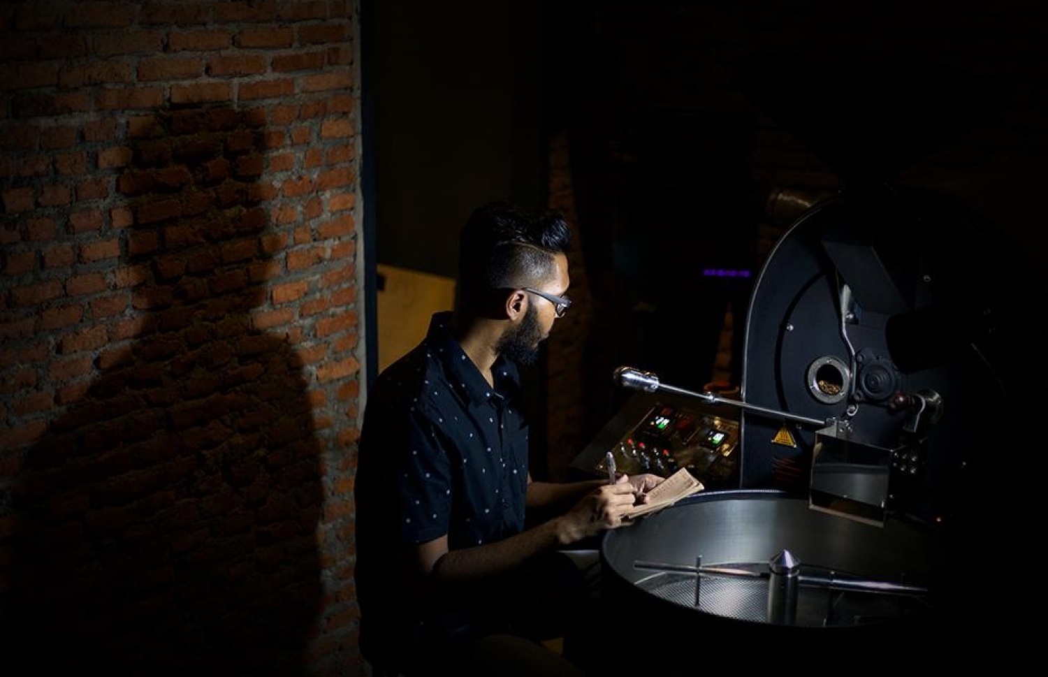 މެރާކީ ކޮފީ ރޯސްޓާސްގައި ޒުވާން މުވައްޒަފަކު ކޮފީ ރޯސްޓްކުރަނީ.--ފޮޓޯ: މެރާކީ