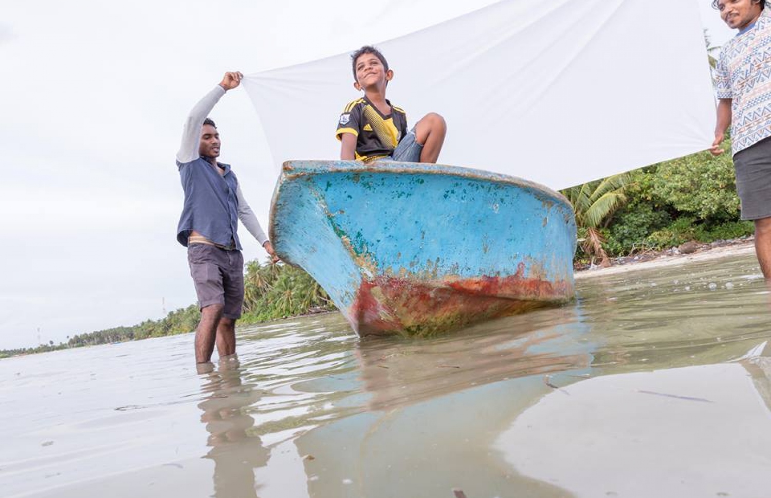 ފޮޓޯއެއް ނެގުމަށް ކުޑަކުއްޖަކު ޑިންގީއެއްގައި: މި ފޮޓޯ ނިންމާލާއިރު ފެންނާނީ އެހެން މަންޒަރެއް