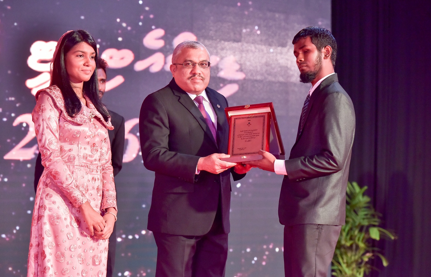 މާލެ: ސެޕްޓެމްބަރު 25، 2016: ނުކުޅެދުންތެރިކަން ހުންނަ މީހުންގެ ތެރޭން ފާހަގަ ކޮށްލެވޭ މީހުންނަށް ދޭ އެވޯޑު ހަފްލާގައި ބޭފުޅަކަށް ހަނދާނީ ލިޔުމެއް ދެއްވަނީ: ނުކުޅެދުންތެރިކަން ހުންނަ މީހުންގެ ތެރެއިން ފާހަގަ ކޮށްލެވޭ މީހުންނާއި އެ ދާއިރާއަށް އެކި ގޮތްގޮތުން އެހީތައް ފޯރުކޮށްދޭ ފަރާތްތަކަށް 15 އެވޯޑު ދީފައިވޭ-- ފޮޓޯ: ނިޝާން އަލީ/ މިހާރު