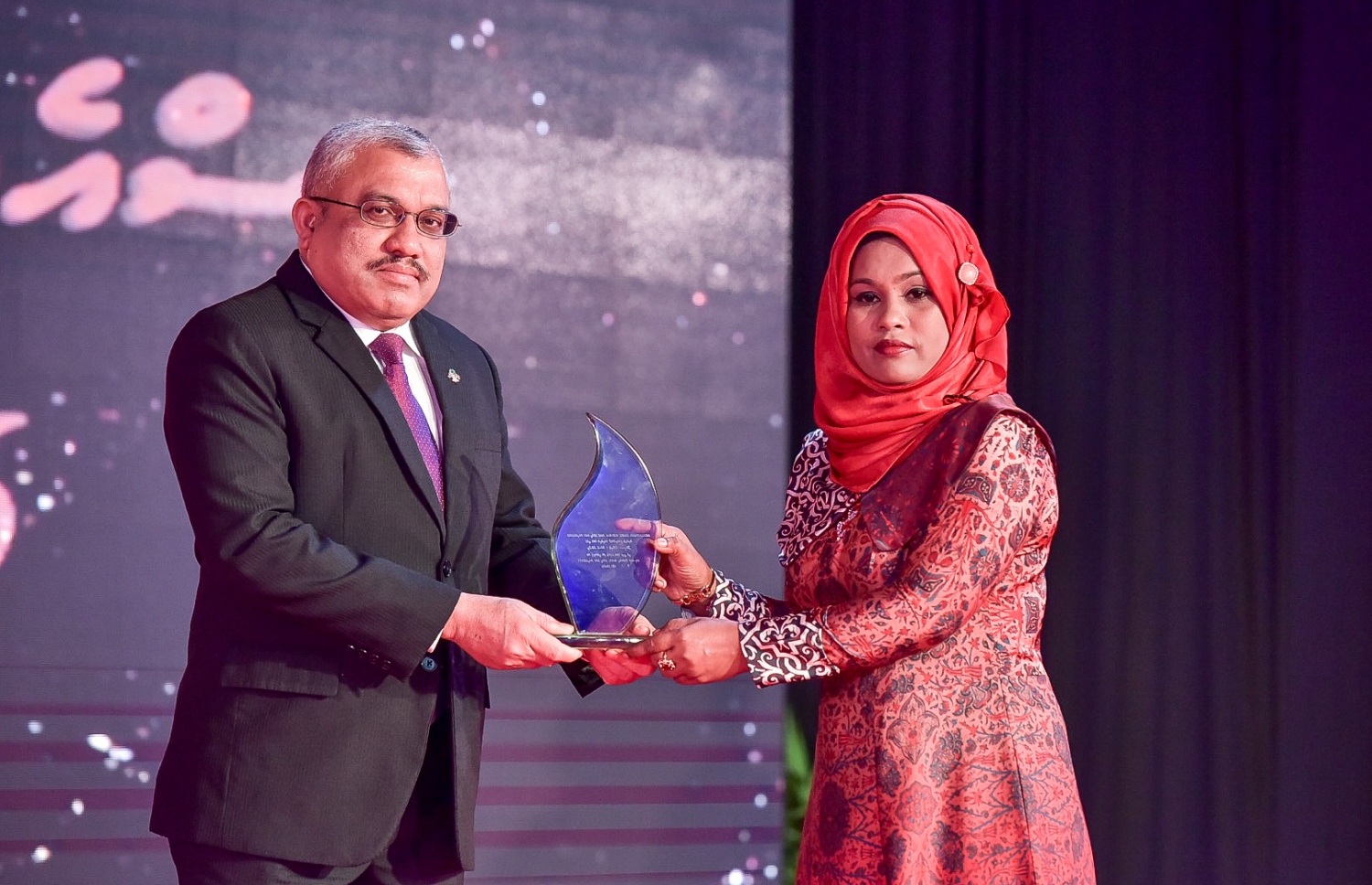 މާލެ: ސެޕްޓެމްބަރު 25، 2016: ނުކުޅެދުންތެރިކަން ހުންނަ މީހުންގެ ތެރޭން ފާހަގަ ކޮށްލެވޭ މީހުންނަށް ދޭ އެވޯޑު ހަފްލާގައި ބޭފުޅަކަށް ހަނދާނީ ލިޔުމެއް ދެއްވަނީ: ނުކުޅެދުންތެރިކަން ހުންނަ މީހުންގެ ތެރެއިން ފާހަގަ ކޮށްލެވޭ މީހުންނާއި އެ ދާއިރާއަށް އެކި ގޮތްގޮތުން އެހީތައް ފޯރުކޮށްދޭ ފަރާތްތަކަށް 15 އެވޯޑު ދީފައިވޭ-- ފޮޓޯ: ނިޝާން އަލީ/ މިހާރު