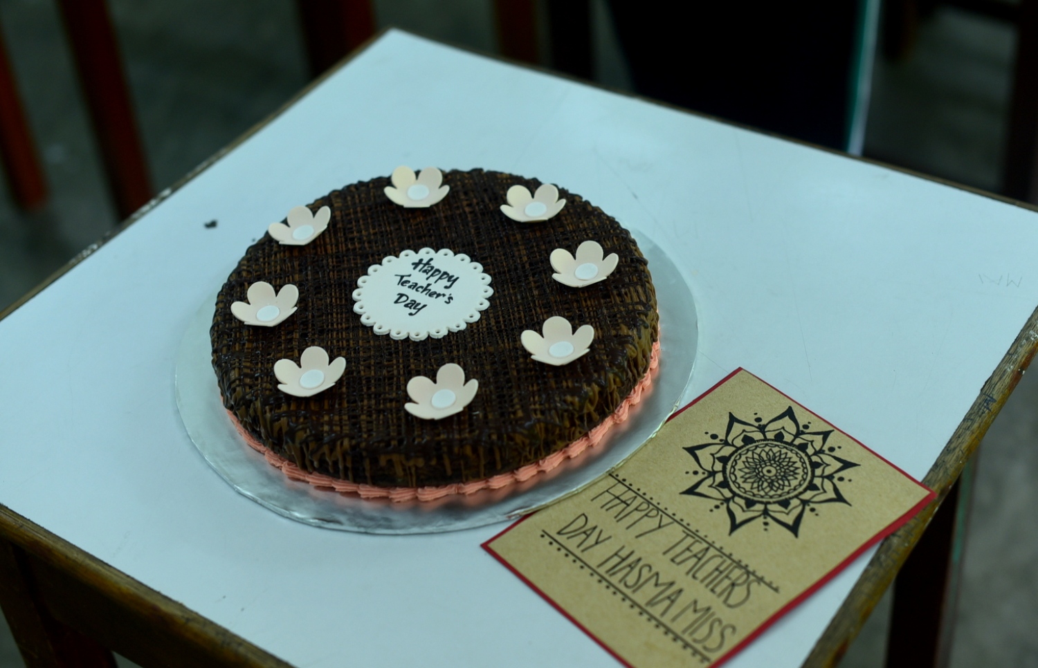 މާލެ: އޮކްޓޯބަރު 4، 2016: ޓީޗަރުންގެ ދުވަހާ ގުޅުވައިގެން، އަމީނިއްޔާ ސްކޫލުގެ ޓީޗަރަކަށް އަޅާފައިވާ ކޭކަކާއި އަދި ކާޑެއް: ޓީޗަރުންގެ ދުވަހަކީ އޮކްޓޯބަރު 5 ކަމަށް ވިޔަސް ދެ ދުވަސް ކުރިން ފެށިގެން ސްކޫލުތަކުގައި އަންނަނީ ޓީޗަރުންގެ ދުވަސް ފާހަގަކުރަމުން.--- ފޮޓޯ: ހުސެން ޝަޔާހު/މިހާރު