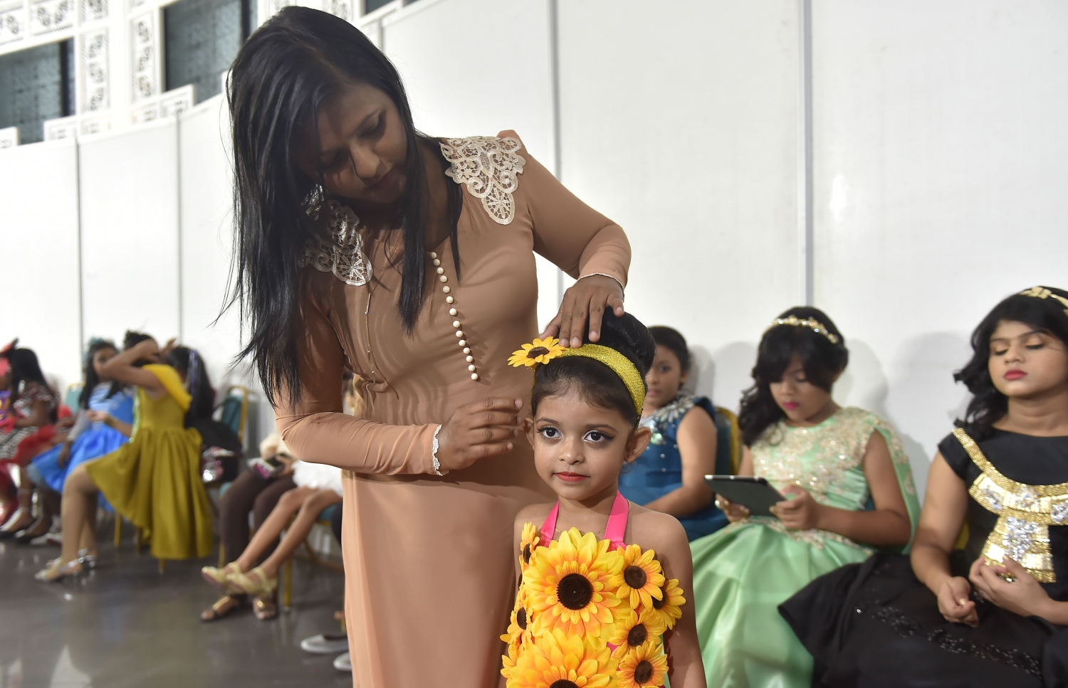 ކުޑަ އަންހެން ކުދިންނަށް ހާއްސަ ހެދުންތަކެއް ދައްކާލުމަށް ކުދިން ހެދުން އަޅުވައި ޒީނަތްތެރިކުރަނީ.--- ފޮޓޯ: މުހައްމަދު ޝަރުހާން/ މިހާރު