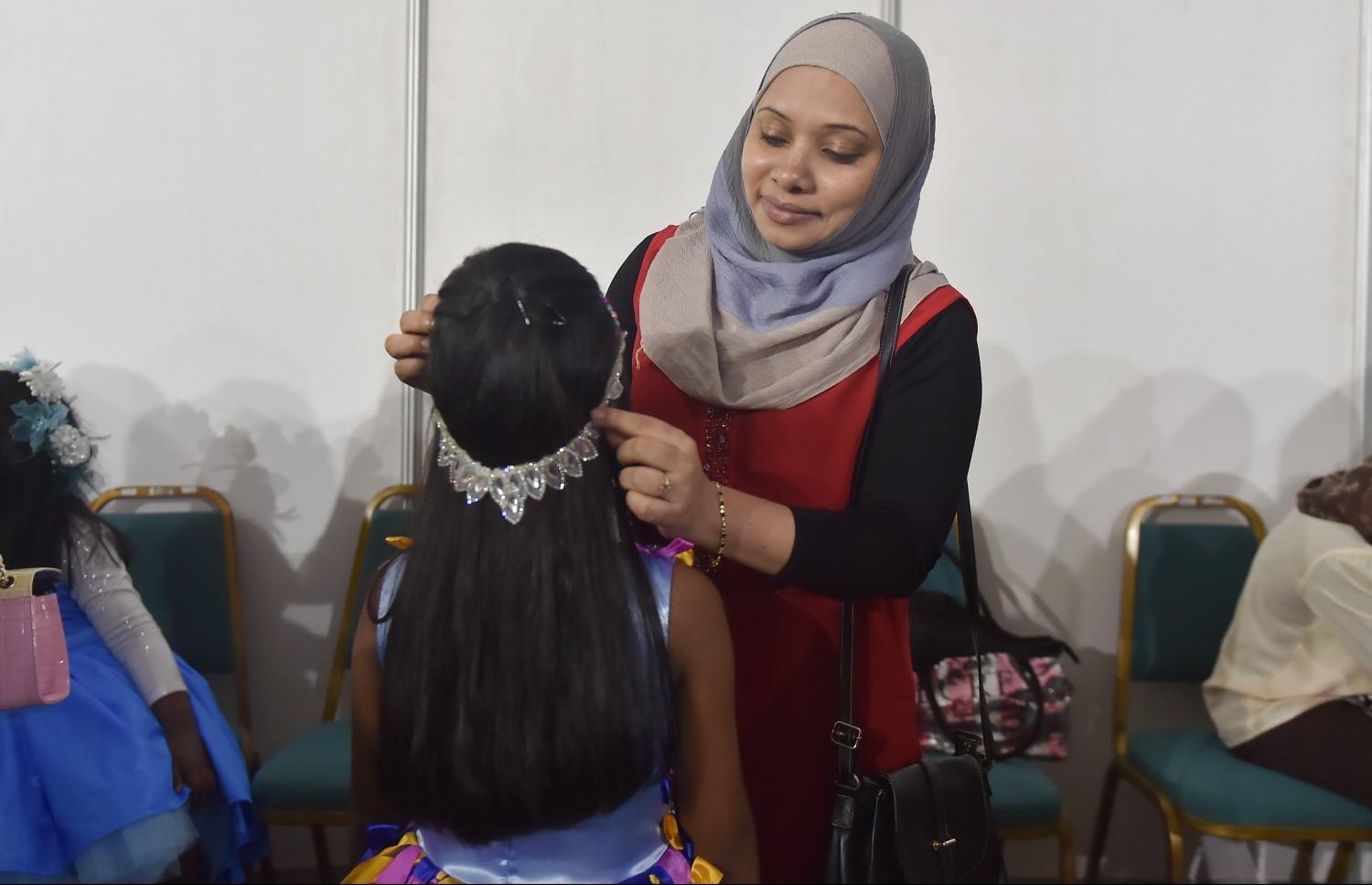 ކުޑަ އަންހެން ކުދިންނަށް ހާއްސަ ހެދުންތަކެއް ދައްކާލުމަށް ކުދިން ހެދުން އަޅުވައި ޒީނަތްތެރިކުރަނީ.--- ފޮޓޯ: މުހައްމަދު ޝަރުހާން/ މިހާރު