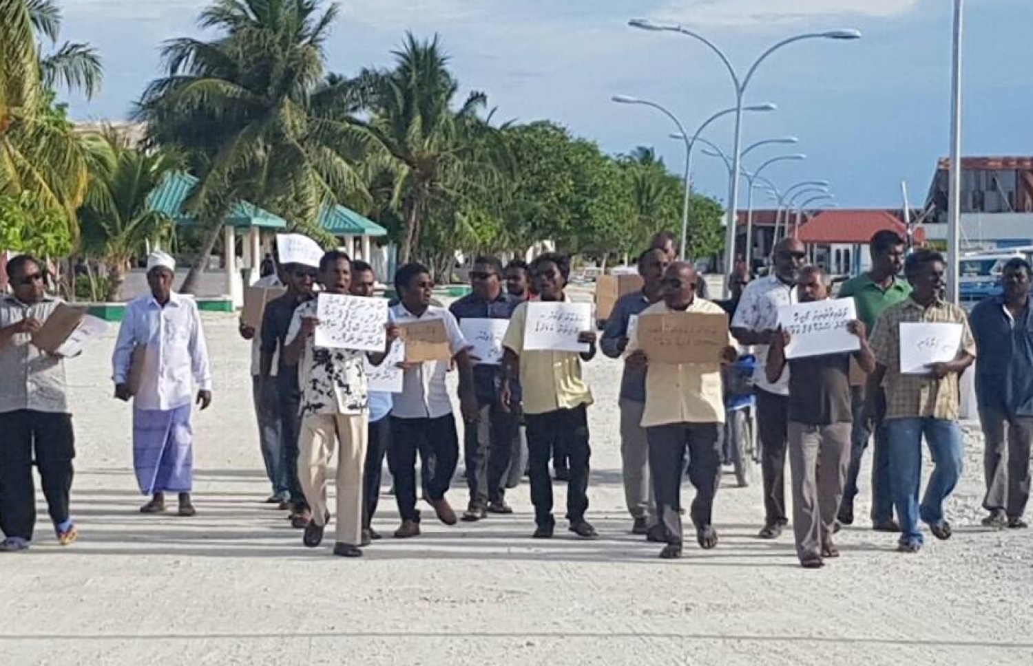ކާޑުގެ އަގު ބޮޑުކުރި މައްސަލާގައި ބޯޑުތައް ހިފައިގެން ބަޔަކު މުޒާހަރާކުރަނީ.