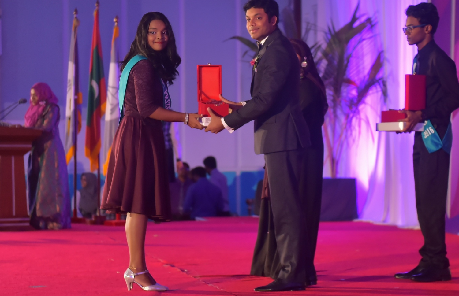 މާލެ: އޮކްޓޯބަރު 8، 2016- އަހުމަދިއްޔާ އިންޓަނޭޝަނަލް ސްކޫލުގެ އިނާމު ދިނުމަށް ބޭއްވި ޖަލްސާގައި ދަރިވަރަކާ އިނާމު ހަވާލުކޮށްދެއްވަނީ: އެ ސްކޫލުން މިދިޔަ އަހަރު ސެކަންޑަރީ ބައިން އެއްވަނަ ހޯދީ ފާތިމަތު ނަޝާ އަލީ އަދި ހަޔަ ސެކަންޑްރީ ބައިގެ އެއްވަނަ ދަރިވަރަކީ އާމިނަތު ރިފްޒާ.---ފޮޓޯ: މުހައްމަދު ޝަރުހާން/މިހާރު