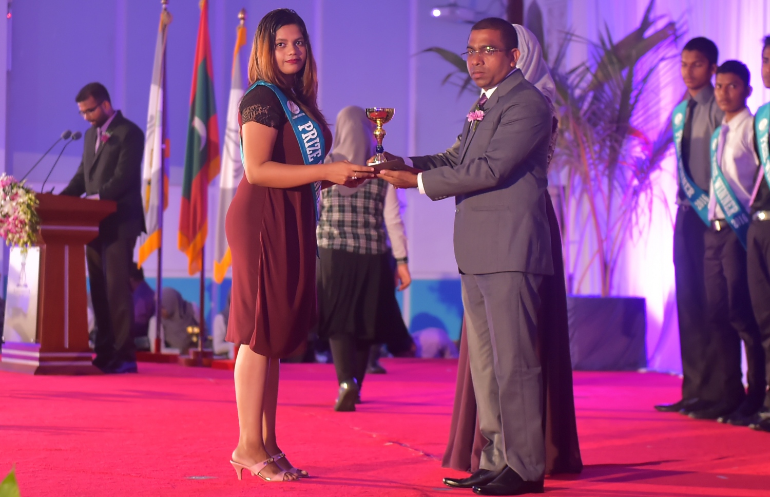 މާލެ: އޮކްޓޯބަރު 8، 2016- އަހުމަދިއްޔާ އިންޓަނޭޝަނަލް ސްކޫކުގެ އިނާމު ދިނުމުގެ ހަފުލާގައި، ގެމަނަފުށި ދާއިރާގެ މެމްބަރު ޖަމީލް އުސްމާން ދަރިވަރަކަށް އިނާމު ހަވާލުކޮށްދެއްވަނީ: އެ ސްކޫލުން މިދިޔަ އަހަރު ސެކަންޑަރީ ބައިން އެއްވަނަ ހޯދީ ފާތިމަތު ނަޝާ އަލީ އަދި ހަޔަ ސެކަންޑްރީ ބައިގެ އެއްވަނަ ދަރިވަރަކީ އާމިނަތު ރިފްޒާ.---ފޮޓޯ: މުހައްމަދު ޝަރުހާން/މިހާރު