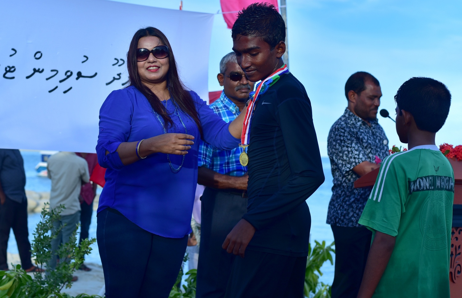 ގދ. ތިނަދޫ: އޮކްޓޯބަރު 25، 2016: ސްވިމިން ޓްރެކް ހުޅުވުމަށް ޔޫތު މިނިސްޓަރު އިރުތިޝާމް ގދ. ތިނަދޫ އަށް ކުރެއްވި ދަތުރުފުޅުގައި، ޓްރެކް ހުޅުވުމަށް ބޭއްވި ރިލޭ އިވެންޓެއްގައި ވަނަތަކަށް އައި ކުދިންނަށް މެޑަލް ހަވާލު ކުރައްވަނީ.--- ފޮޓޯ: މިހާރު