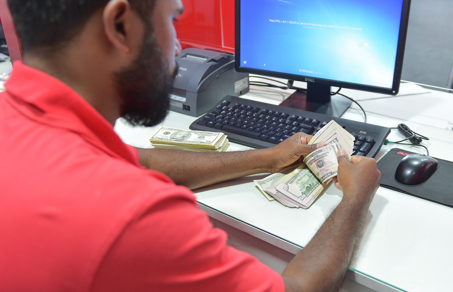 ބީއެމްއެލްގެ މުވައްޒަފަކު ޑޮލަރު ގުނަނީ: ކަޅު ބާޒާރުން ޑޮލަރު ގަންނަން ޖެހެނީ ބޭންކުން ބޭނުންވާ ވަރަށް ޑޮލަރު ނުލިބޭތީ ކަމަށް ވިޔަފާރިވެރިން ބުނޭ.---މިހާރު ފޮޓޯ