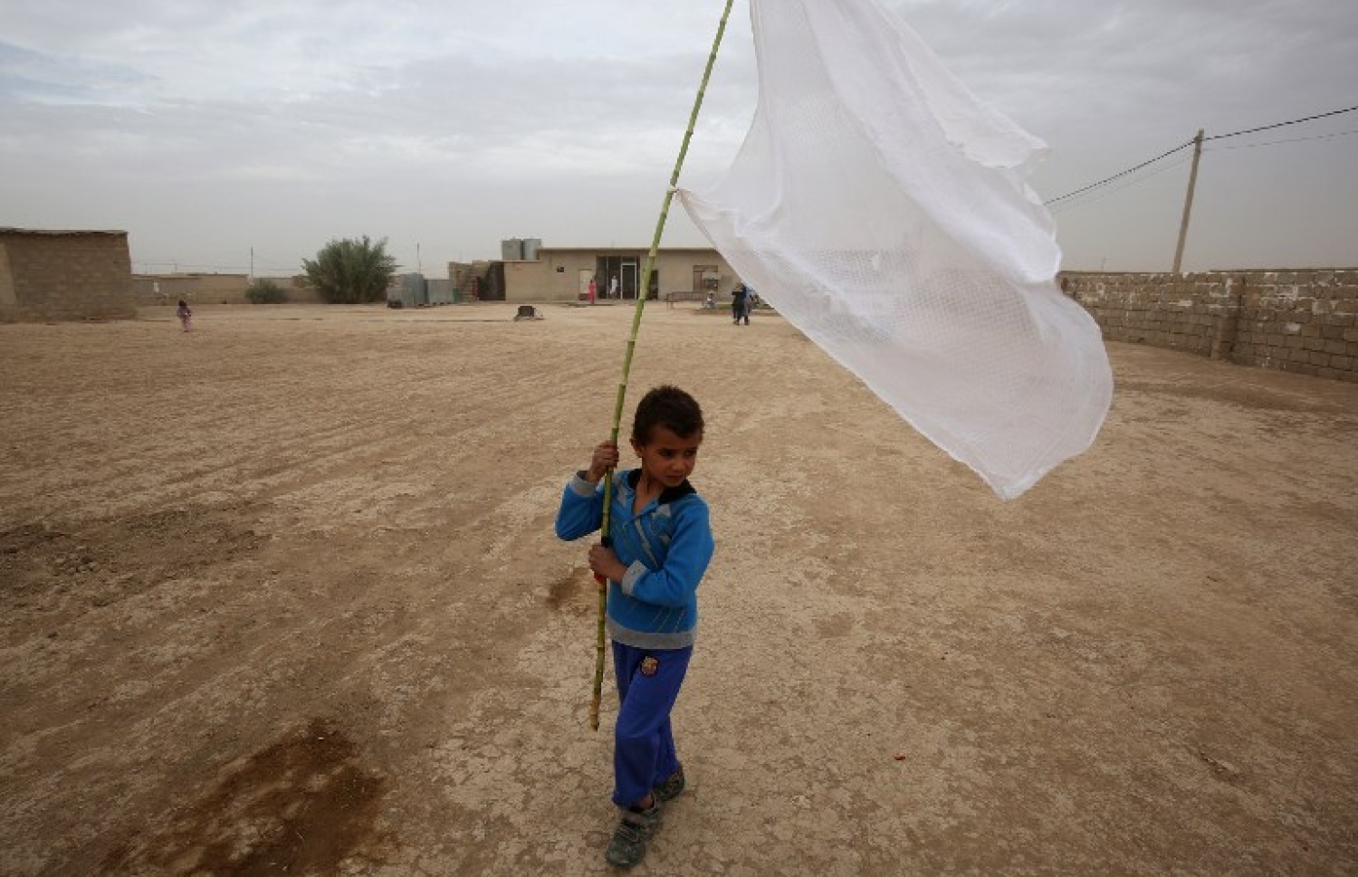 އިރާގު ސިފައިން މޫސަލް އަށް ވަންނަން ތައްޔާރުވި އިރު އެ ސިޓީގެ ދެކުނުން އޮތް އަވަށެއްގައި ކުޑަ ކުއްޖަކު ހުދު ދިދައެއް ހިފައިގެން. --ފޮޓޯ:އޭއެފްޕީ