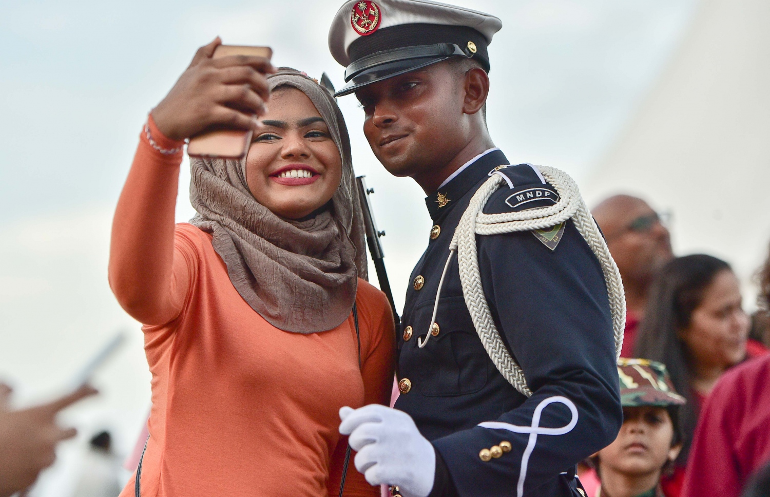 މާލެ: ނޮވެމްބަރު 3، 2016: ނަސްރުގެ ދުވަހުގެ މުނާސަބަތުގައި ނޮވެމްބަރު 3 2016 ވަނަ ދުވަހުގެ ހަވީރު އެމްއެންޑީއެފް އިން ޖުމްހޫރީ މައިދާނުގައި ބޭއްވި ސައިލެންޓް ޑްރިލް ބަލާލަން ގޮސް ތިބި އާއްމުންގެ ބަޔަކާ އެކު ސިފައިންގެ މީހަކު ފޮޓޯއެއް ނަގަނީ.-- ފޮޓޯ: މުހައްމަދު ޝަރުހާން/ މިހާރު