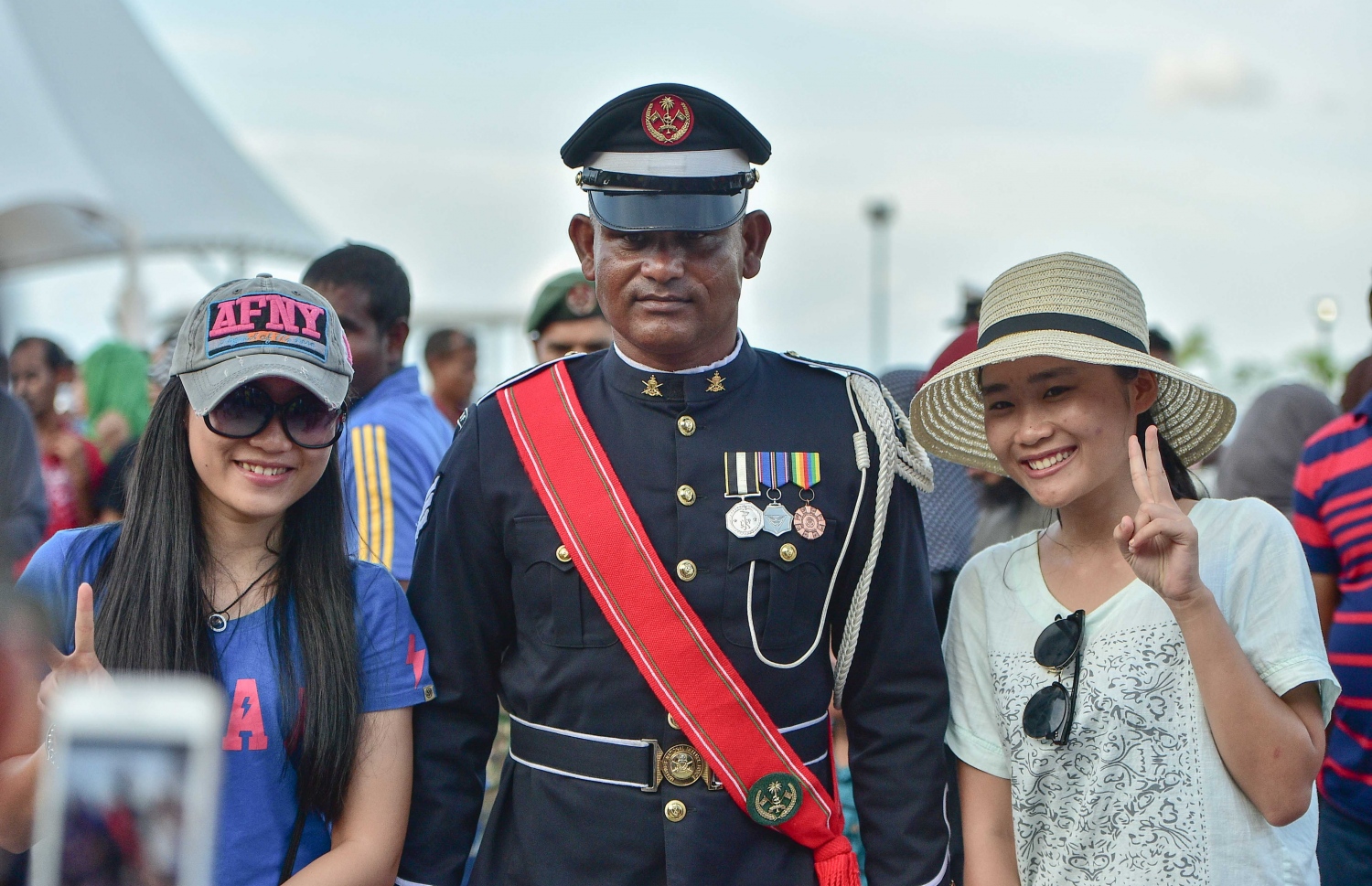 މާލެ: ނޮވެމްބަރު 3، 2016: ނަސްރުގެ ދުވަހުގެ މުނާސަބަތުގައި ނޮވެމްބަރު 3 2016 ވަނަ ދުވަހުގެ ހަވީރު އެމްއެންޑީއެފް އިން ޖުމްހޫރީ މައިދާނުގައި ބޭއްވި ސައިލެންޓް ޑްރިލް ބަލާލަން ގޮސް ތިބި އާއްމުންގެ ބަޔަކާ އެކު ސިފައިންގެ މީހަކު ފޮޓޯއެއް ނަގަނީ.-- ފޮޓޯ: މުހައްމަދު ޝަރުހާން/ މިހާރު