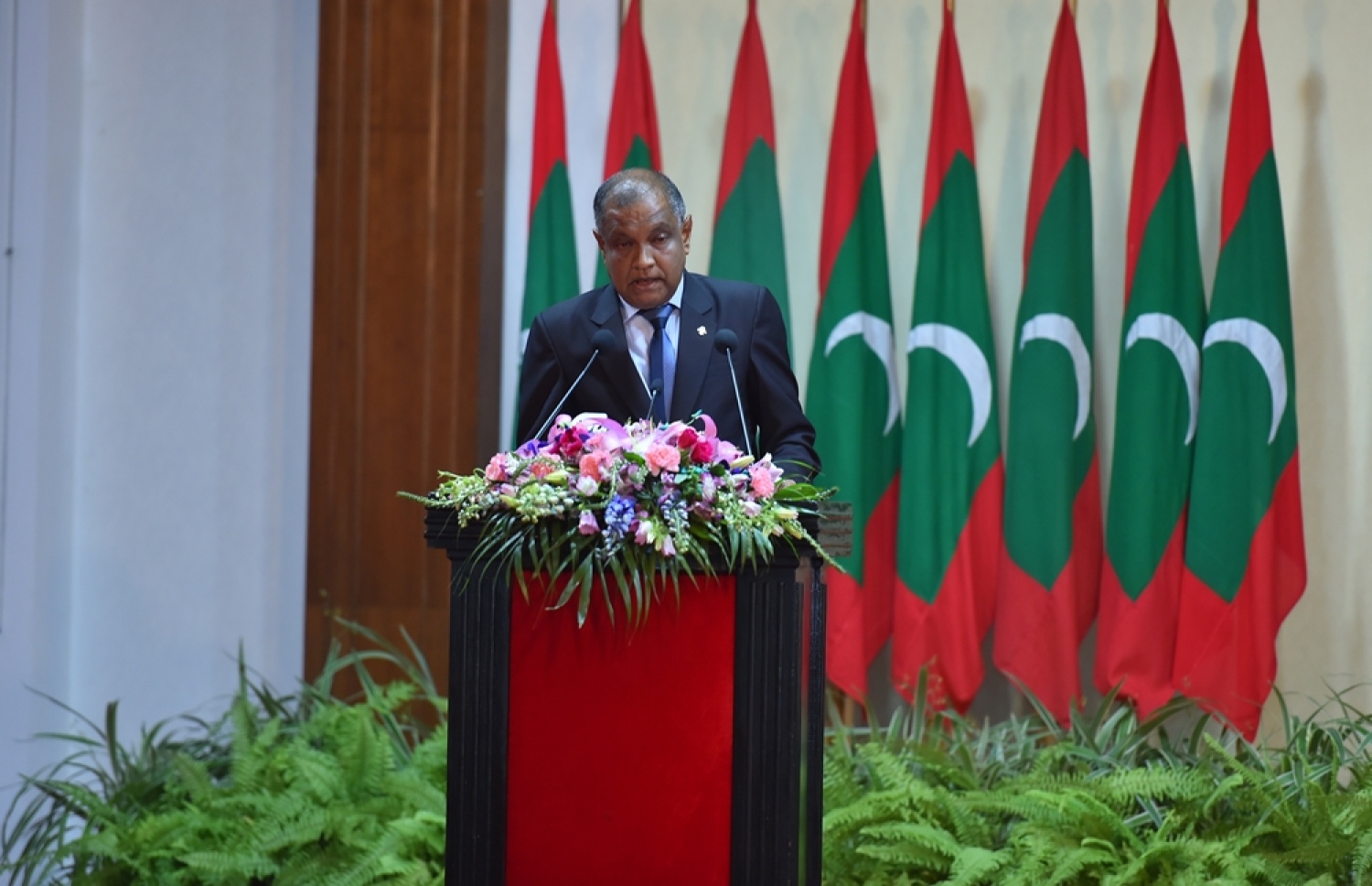 މާލެ: ނޮވެމްބަރު 10، 2016: މި އަހަރުގެ ޖުމްހޫރީ ދުވަހުގެ މުނާސަބަތުގައި ބޭއްވި ރަސްމީ ޖަލްސާގައި، ޝަރަފުވެރިކަމުގެ ގައުމީ އިނާމާއި ހިތްވަރު ދިނުމުގެ ގައުމީ އިނާމު އަދި އެހެނިހެން އިނާމުތައް ލިބިވަޑައިގެންނެވި ބޭފުޅުންގެ ނަންތައް، ރައީސް އޮފީހުގެ އަންޑަ ސެކްރެޓަރީ ހުސެއިން އާމިރު އިއުލާން ކުރައްވަނީ.---ފޮޓޯ: ރައީސް އޮފީސް