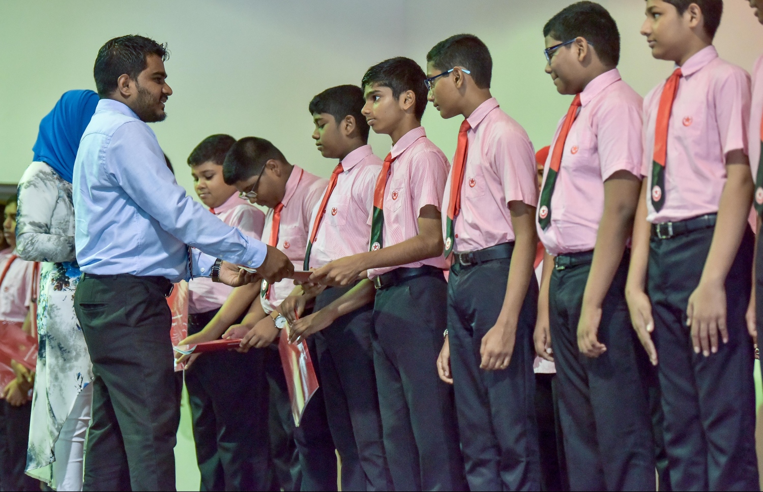 އިސްކަންދަރު ސްކޫލުގެ ދަރިވަރަކަށް އެ ސްކޫލުގެ ލީޑިން ޓީޗަރަކު ރިޕޯޓު ފޮތް ހަވާލުކޮށްދެނީ: ސްކޫލުތަކުގެ ކިޔެވުން ދެން ފެށޭނީ އަންނަ ޖެނުއަރީ އަށް ވަނަ ދުވަހު.-- ފޮޓޯ: ނިޝާން އަލީ/ މިހާރު