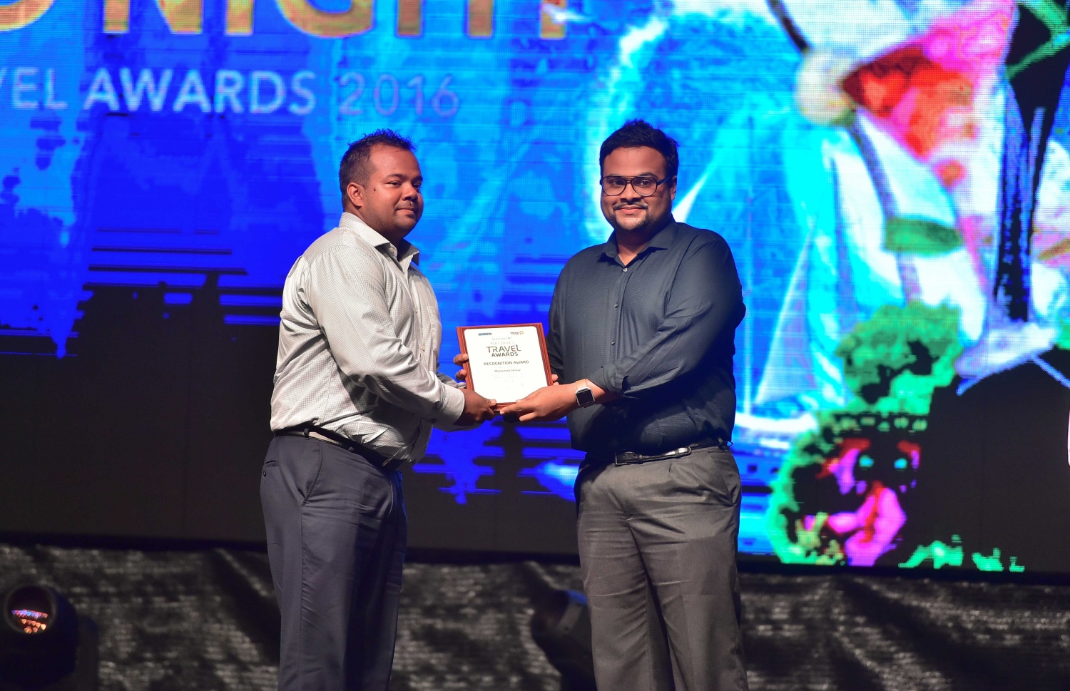 އޮޅުވެލި ރިސޯޓު: ނޮވެމްބަރު 20، 2016: ރާއްޖޭގެ ޓޫރިޒަމްގެ ސިނާއަތުގައި ދޭ އެންމެ ބޮޑު އަދި އެންމެ ޝަރަފްވެރި އެވޯޑް ކަމަށްވާ މޯލްޑިވްސް ޓްރެވަލް އެވޯޑްސް ހަފްލާގައި ޓްރަވެލް އެވޯޑުގެ ފަނޑިޔާރުކަން ކުރެއްވި ބޭފުޅަކަށް ހަނދާނީ ލިޔުމެއް ދެނީ: މިއަހަރު 35 ކެޓެގަރީ އަކުން ވަނީ އެވޯޑް ދީފައި، އެންމެ ގިނަ އެވޯޑުތައް ވަނީ ބަނޑޮސް އައިލެންޑް ރިސޯޓުން ހޯދައިފައި، އަދި އެންމެ މޮޅު ލަގްޒަރީ ރިސޯޓަކަށް ވަނީ ކޮންރަޑް މޯލްޑިވްސް ރަންގަލި ރިސޯޓް ހޮވިފައި.-- ފޮޓޯ: މުހައްމަދު ޝަރުހާން/ މިހާރު