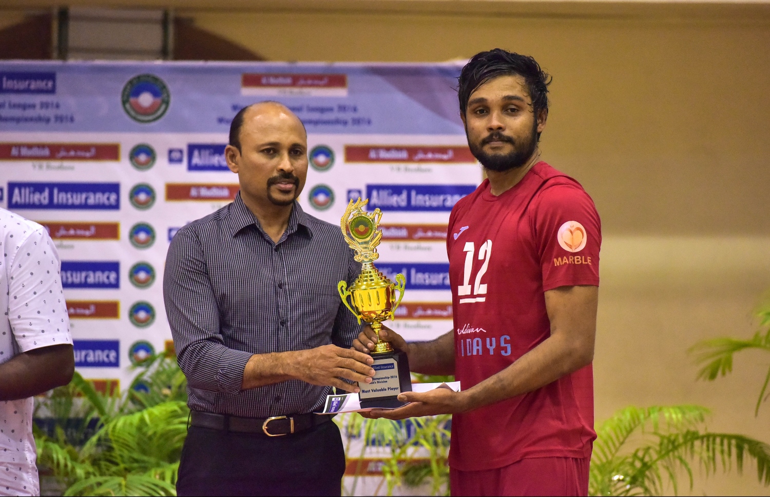 ހުޒާމް (ކ) އަށް މޮޅު ކުޅުންތެރިޔާގެ އެވޯޑް ހޯމް މިނިސްޓަރުގެ ނައިބް އަދި ކުރީގެ ވޮލީބޯޅަ ކޯޗު މާޒް ސަލީމް ދެނީ. --ފޮޓޯ: ނިޝާން އަލީ/ މިހާރު