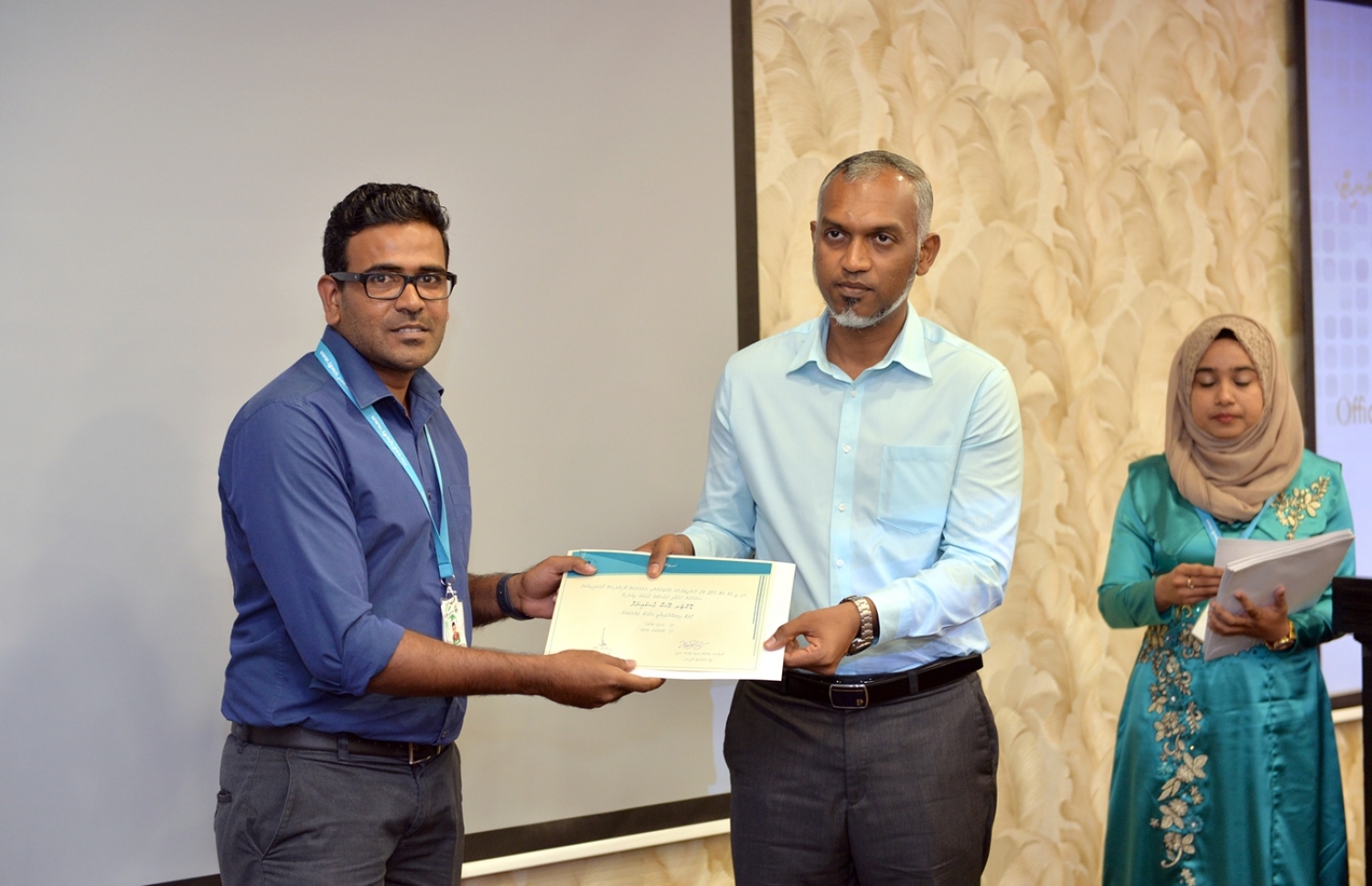 އައިޖީއެމްއެޗު މުވައްޒަފުންގެ ތެރެއިން ފްލެޓް ލިބުނު، ޑޮކްޓަރު މޫސާ ހުސައިނަށް، ހައުސިން މިނިސްޓަރު މުއިއްޒު، ލިޔުން ހަވާލުކޮށްދެއްވަނީ. ފޮޓޯ: ރައީސް އޮފީސް