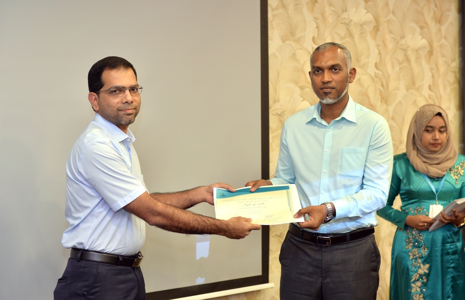 އައިޖީއެމްއެޗު މުވައްޒަފުންގެ ތެރެއިން ފްލެޓް ލިބިވަޑައިގެން، ޑޮކްޓަރު އަލީ ޝަފީގަށް، ހައުސިން މިނިސްޓަރު މުއިއްޒު، ލިޔުން ދެއްވަނީ: މި ފްލެޓް އެތަނުގެ 20 މުވައްޒަފަކަށް ލިބިފައިވޭ-- ފޮޓޯ: ރައީސް އޮފީސް