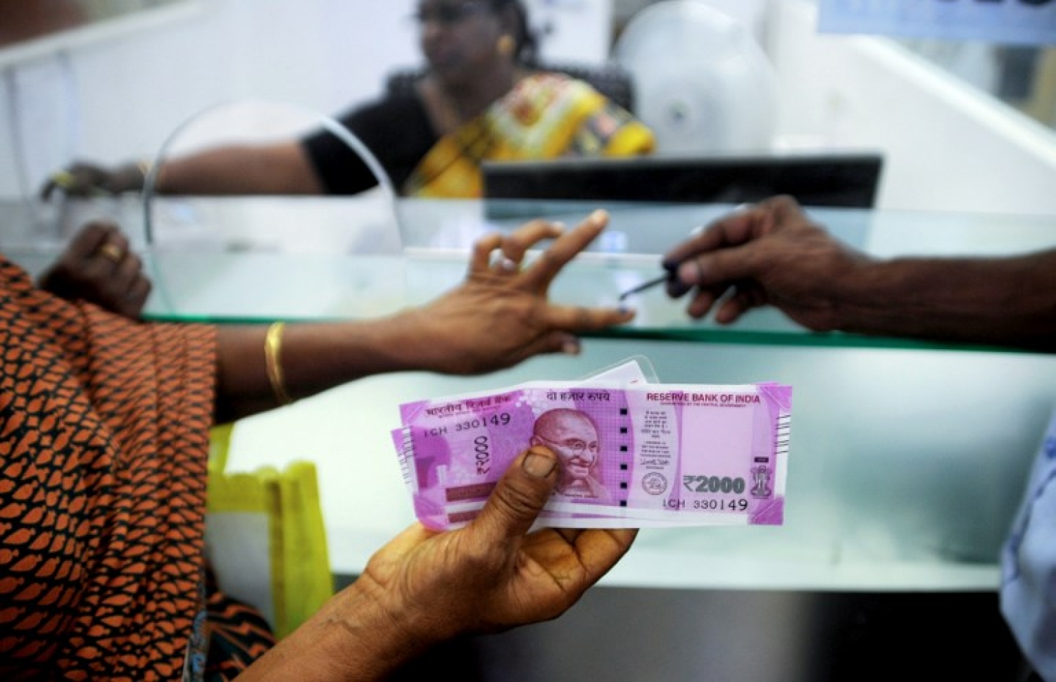 އިންޑިއާގެ ޗެންނާއީގައި މީހަކު ކުރީގެ ފައިސާ ބަދަލުކޮށް އާ ނޫޓް ނަގަނީ. --ފޮޓޯ:އޭއެފްޕީ