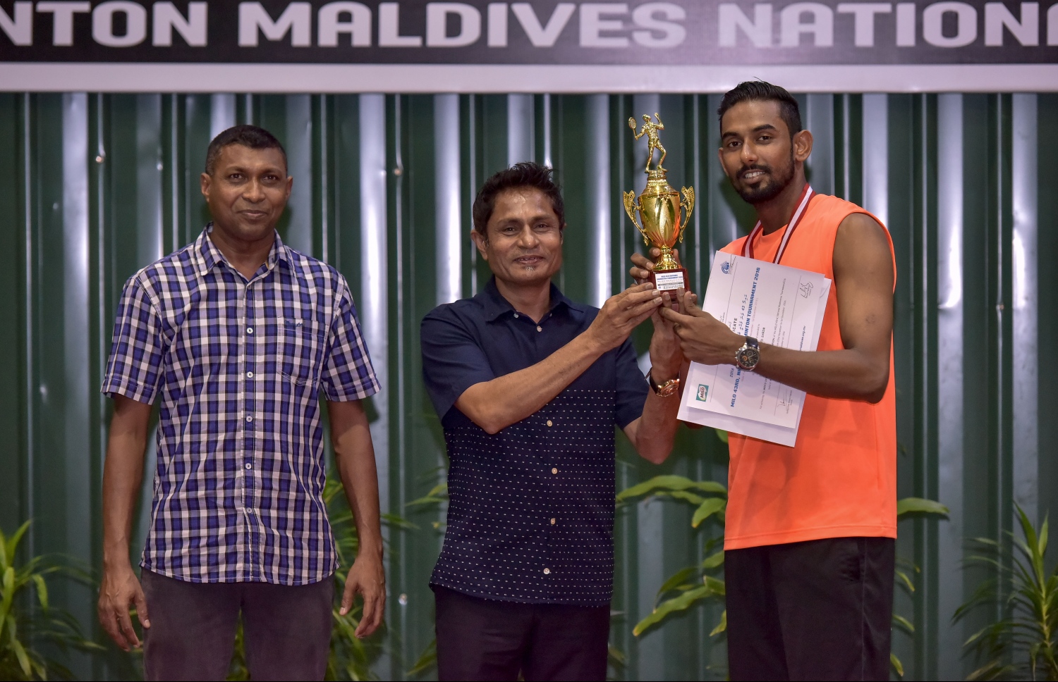 ފުރަތަމަ ޑިވިޝަން ސިންގަލްސް ޗެމްޕިއަންކަން ހޯދި ސާރިމް (ކ)އާ މޯލްޑިވްސް ސްޕޯޓްސް ކޯޕަރޭޝަންގެ މެނޭޖިން ޑިރެކްޓަރު ރައްޒާގު އެވޯޑް ހަވާލުކުރަނީ.-- ފޮޓޯ: ނިޝާން އަލީ/ މިހާރު