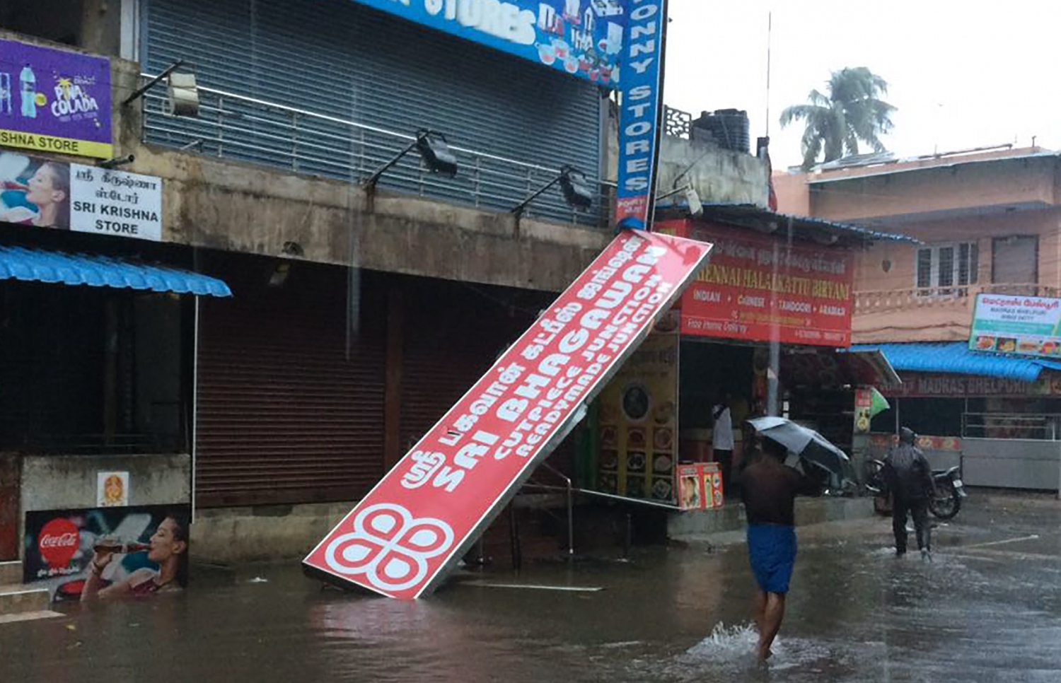 އިންޑިއާ، ޗެންނާއީ: ޑިސެމްބަރު 12، 2016: ޗެންނާއީ އަށް އެރި ތޫފާނުގައި ފެންބޮޑުވެފައިވާ މަގެއްގައި މީހަކު ހިނގާފައި ދަނީ. -- ފޮޓޯ: އޭއެފްޕީ