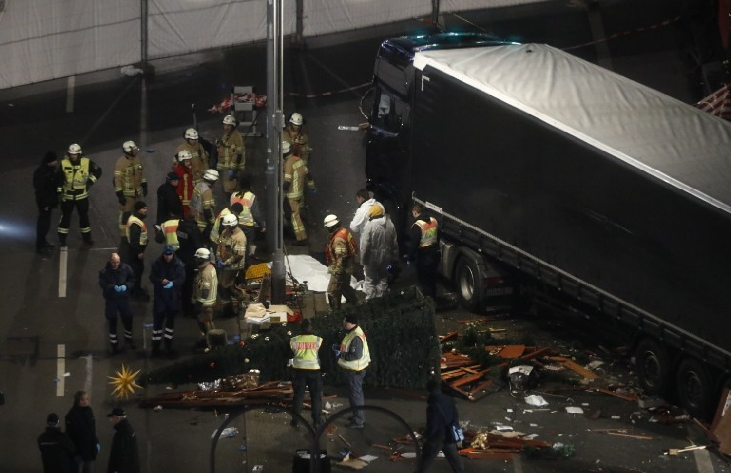 ބާލިންގެ ކްރިސްމަސް މާރުކޭޓަކަށް ލޮރީ ވައްދާލި ސަރަހައްދު ޖަރުމަނުގެ ކަމާ ބެހޭ އޮފިޝަލުން އިންސްޕެކްޓް ކުރަނީ. --ފޮޓޯ:އޭއެފްޕީ