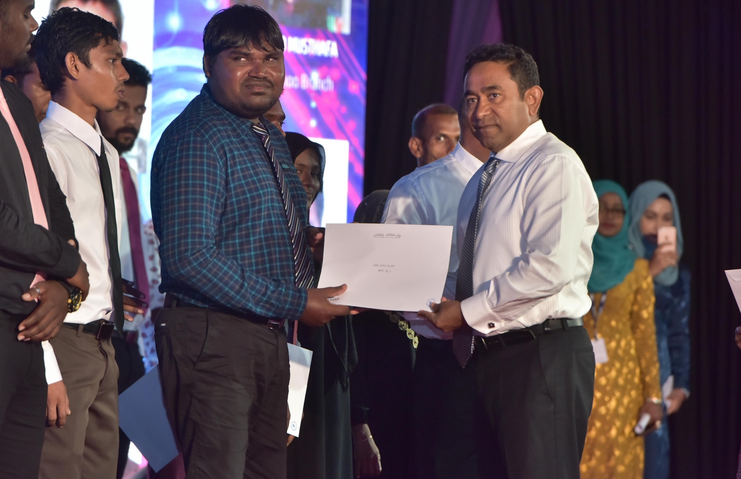 މާލެ: ޑިސެމްބަރު 25، 2016: ނުކުޅެދުންތެރިކަން ހުންނަ 100 މީހަކަށް ފެނަކަ ކޯޕަރޭޝަނުން ވަޒީފާ ހަމަޖައްސައި ލިޔުން ހަވާލުކުރަން ދަރުބާރުގޭގައި ބޭއްވި ރަސްމިއްޔާތުގައި، ފެނަކަ އިން ވަޒީފާ ހަމަޖެއްސި މީހަކަށް ރައީސް ޔާމީން ލިއުން ހަވާލުކޮށްދެއްވަނީ.-- ފޮޓޯ: މުހައްމަދު ޝަރުހާން/ މިހާރު