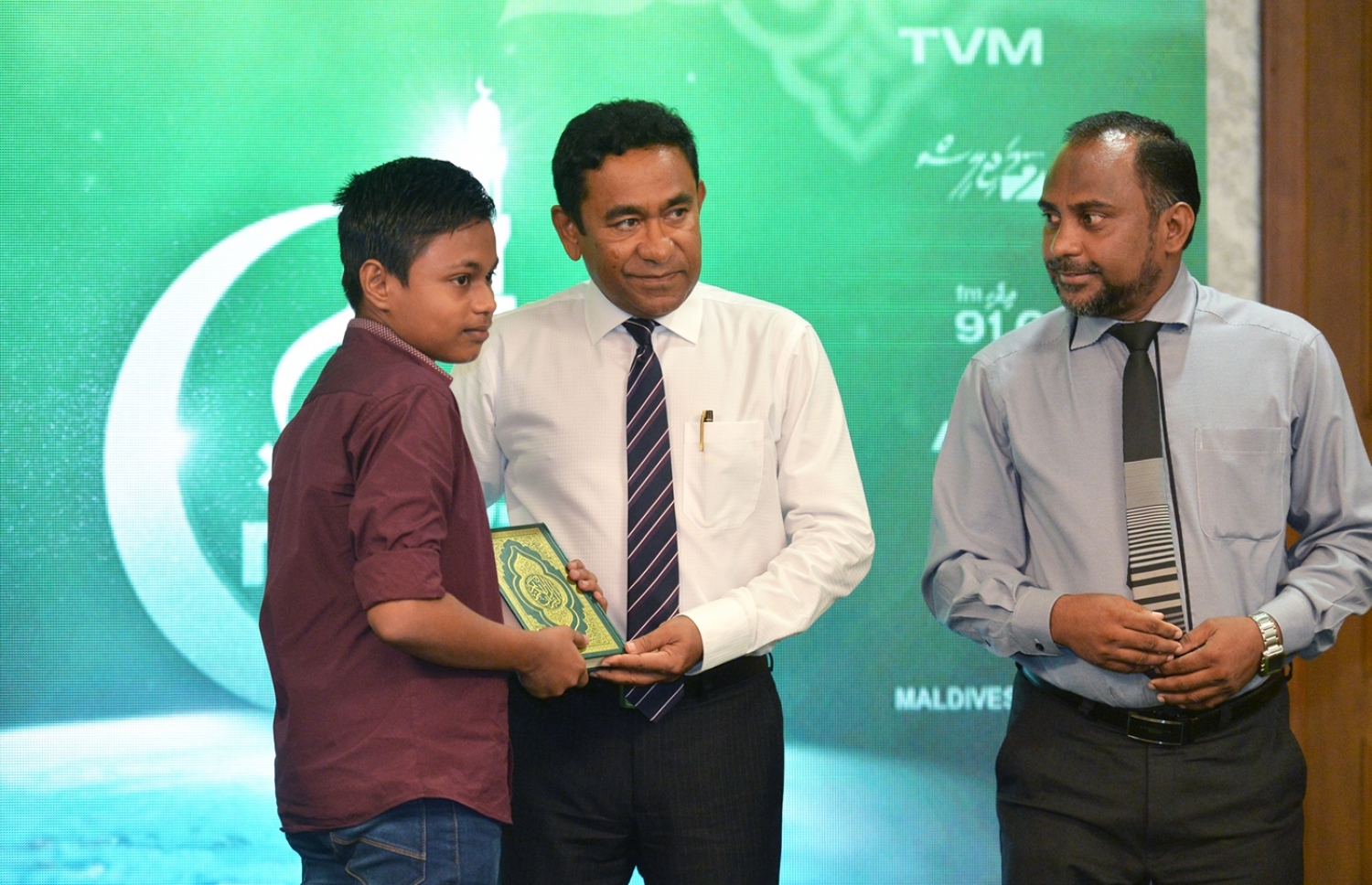 މާލެ: ޑިސެމްބަރު 29، 2016- ރާއްޖެ އަށް ހާއްސަ މުސްހަފެއް ތައްޔާރު ކުރުމަށް ސަރުކާރުން ފެށި މަޝްރޫއުގެ ދަށުން ފުރަތަމަ ޗާޕްކުރި މުސްހަފްތައް ރަސްމީކޮށް ބަހަށް ފެށުމުގެ ގޮތުން، ގުރުއާނާ ބެހޭ މަރުކަޒުގައި، ގުރުއާން ހިތުދަސް ކުރަމުން އަންނަ ކުއްޖަކަށް ރައީސް ޔާމީން މުސްހަފެއް ދެއްވަނީ.--- ފޮޓޯ: ރައީސް އޮފީސް