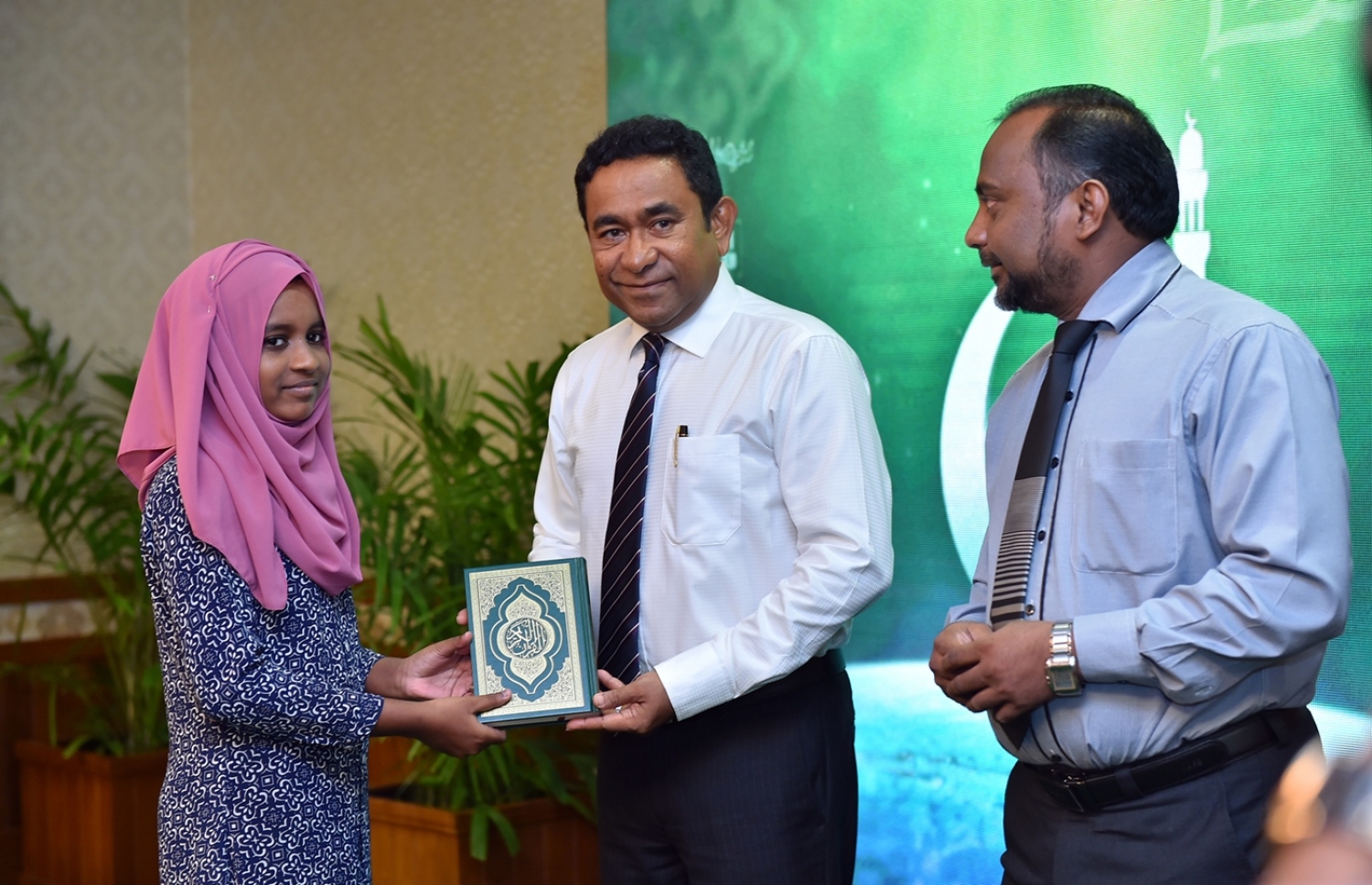 މާލެ: ޑިސެމްބަރު 29، 2016- ރާއްޖެ އަށް ހާއްސަ މުސްހަފެއް ތައްޔާރު ކުރުމަށް ސަރުކާރުން ފެށި މަޝްރޫއުގެ ދަށުން ފުރަތަމަ ޗާޕްކުރި މުސްހަފްތައް ރަސްމީކޮށް ބަހަށް ފެށުމުގެ ގޮތުން، ގުރުއާނާ ބެހޭ މަރުކަޒުގައި، ގުރުއާން ހިތުދަސް ކުރަމުން އަންނަ ކުއްޖަކަށް ރައީސް ޔާމީން މުސްހަފެއް ދެއްވަނީ.--- ފޮޓޯ: ރައީސް އޮފީސް