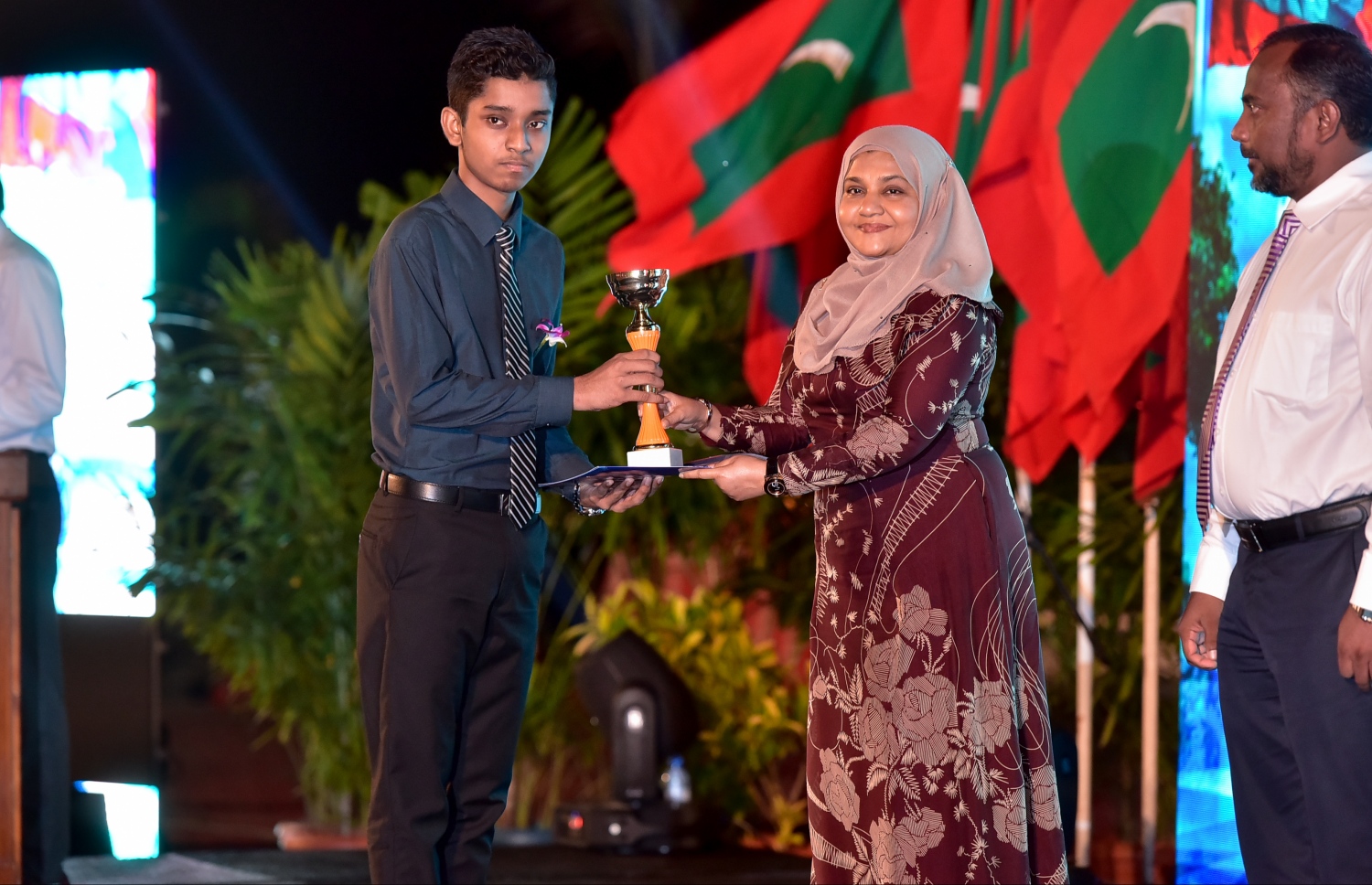 މާލެ: ޖެނުއަރީ 10، 2017- ރާއްޖެ އިސްލާމްވި ދުވަހުގެ މުނާސަބަތުގައި ބޭއްވި ޖަލްސާގައި، މިދިޔަ އަހަރުގެ ގައުމީ ގުރުއާން މުބާރާތުން ވަނައެއް ހާސިލްކުރި ދަރިވަރަކާ، ފަސްޓް ލޭޑީ ފާތުމަތު އިބްރާހިމް އިނާމު ހަވާލުކޮށްދެއްވަނީ.---ފޮޓޯ: ނިޝާން އަލީ/މިހާރު