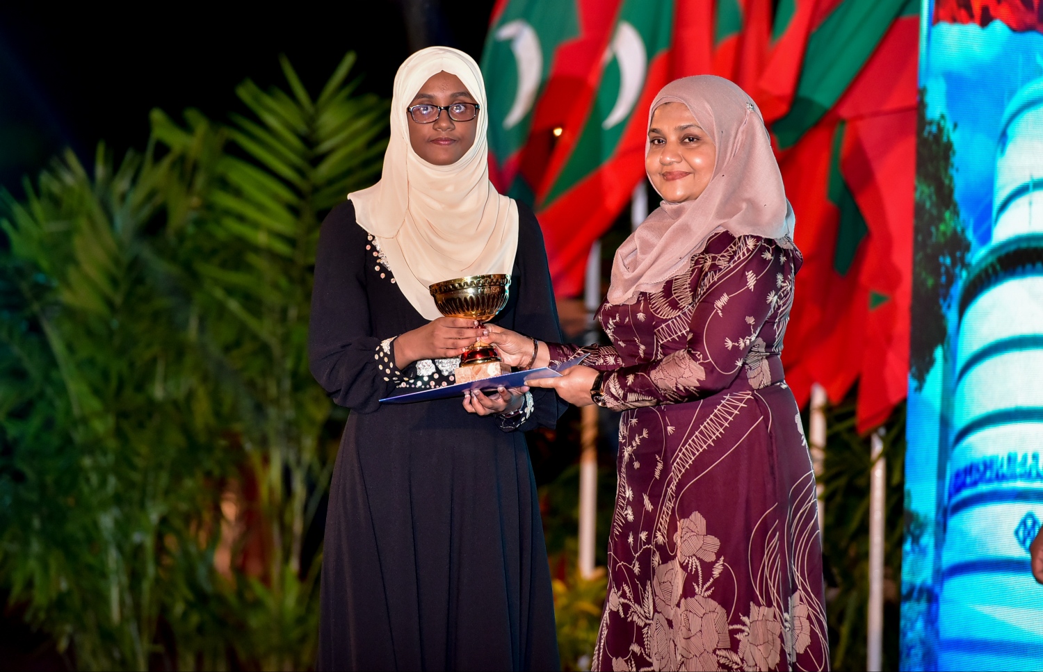 މާލެ: ޖެނުއަރީ 10، 2017- ރާއްޖެ އިސްލާމްވި ދުވަހުގެ މުނާސަބަތުގައި ބޭއްވި ޖަލްސާގައި، މިދިޔަ އަހަރުގެ ގައުމީ ގުރުއާން މުބާރާތުން ވަނައެއް ހާސިލްކުރި ދަރިވަރަކާ، ފަސްޓް ލޭޑީ ފާތުމަތު އިބްރާހިމް އިނާމު ހަވާލުކޮށްދެއްވަނީ.---ފޮޓޯ: ނިޝާން އަލީ/މިހާރު