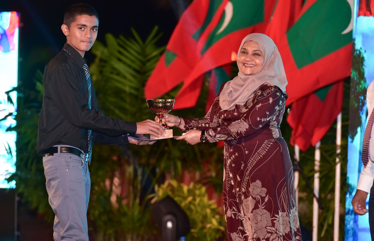 މާލެ: ޖެނުއަރީ 10، 2017- ރާއްޖެ އިސްލާމްވި ދުވަހުގެ މުނާސަބަތުގައި ބޭއްވި ޖަލްސާގައި، މިދިޔަ އަހަރުގެ ގައުމީ ގުރުއާން މުބާރާތުން ވަނައެއް ހާސިލްކުރި ދަރިވަރަކާ، ފަސްޓް ލޭޑީ ފާތުމަތު އިބްރާހިމް އިނާމު ހަވާލުކޮށްދެއްވަނީ.---ފޮޓޯ: ނިޝާން އަލީ/މިހާރު