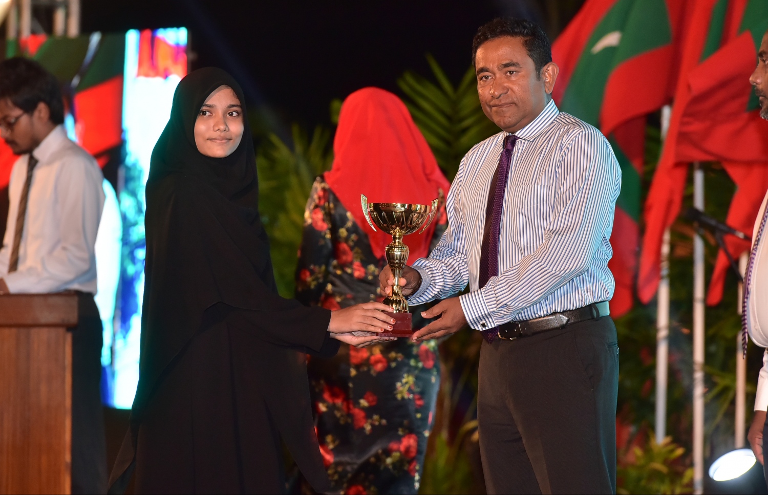 މާލެ: ޖެނުއަރީ 10، 2017- ރާއްޖެ އިސްލާމްވި ދުވަހުގެ މުނާސަބަތުގައި ބޭއްވި ޖަލްސާގައި، މިދިޔަ އަހަރުގެ ގައުމީ ގުރުއާން މުބާރާތުން ވަނައެއް ހާސިލްކުރި ދަރިވަރަކާ ރައީސް ޔާމީން އިނާމު ހަވާލުކޮށްދެއްވަނީ.---ފޮޓޯ: ނިޝާން އަލީ/މިހާރު