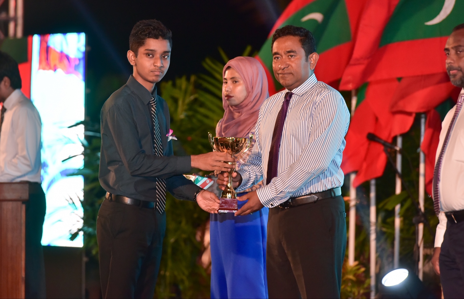 މާލެ: ޖެނުއަރީ 10، 2017- ރާއްޖެ އިސްލާމްވި ދުވަހުގެ މުނާސަބަތުގައި ބޭއްވި ޖަލްސާގައި، މިދިޔަ އަހަރުގެ ގައުމީ ގުރުއާން މުބާރާތުން ވަނައެއް ހާސިލްކުރި ދަރިވަރަކާ ރައީސް ޔާމީން އިނާމު ހަވާލުކޮށްދެއްވަނީ.---ފޮޓޯ: ނިޝާން އަލީ/މިހާރު